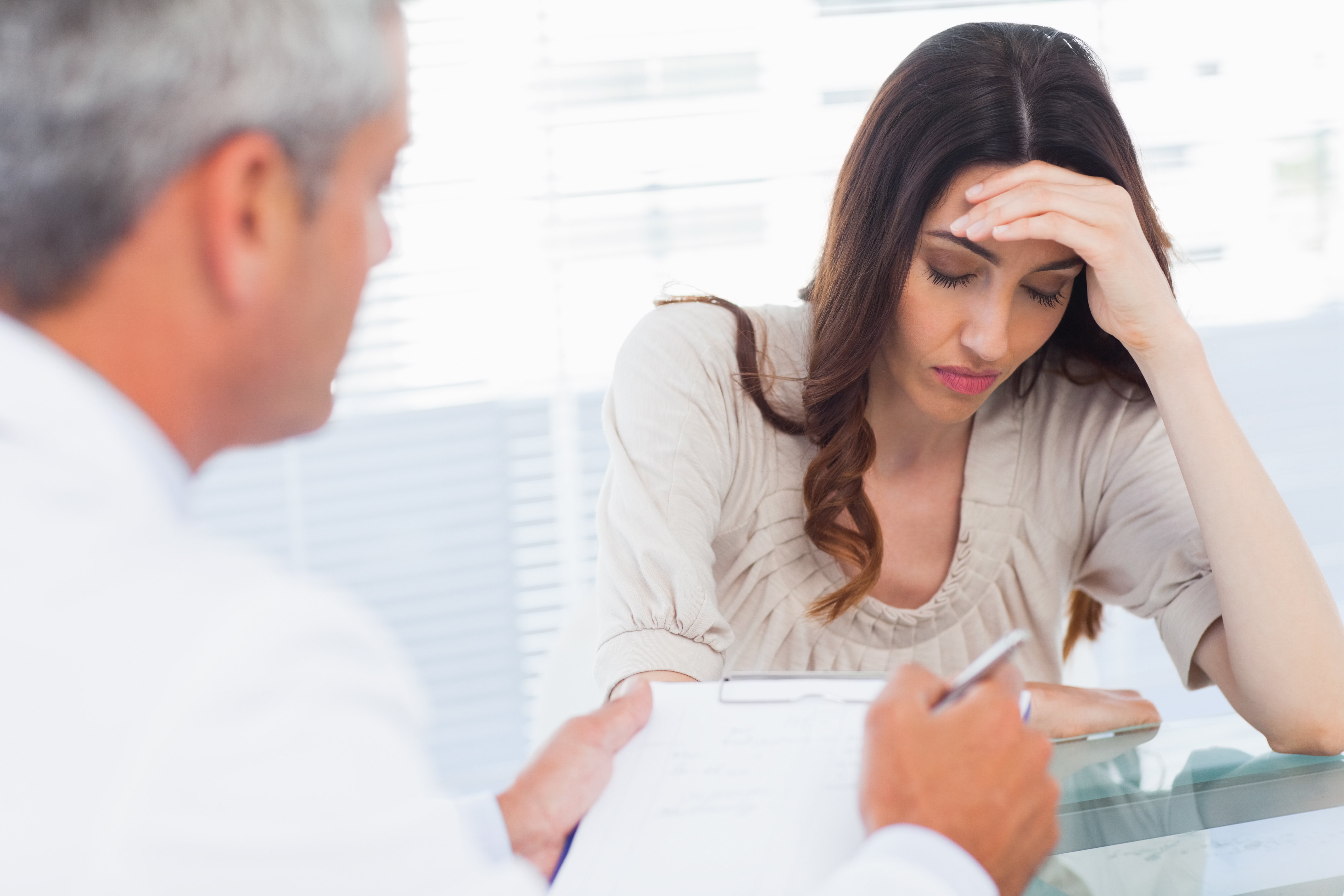 Mujer recibe malas noticias en consultorio médico. | Foto: Shutterstock