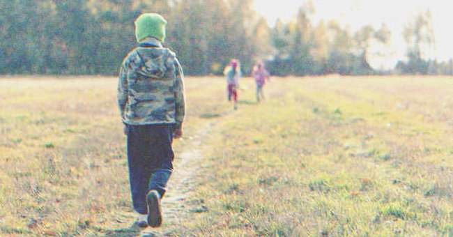 Un niño caminando solo y dos niñas más adelante | Foto: Shutterstock