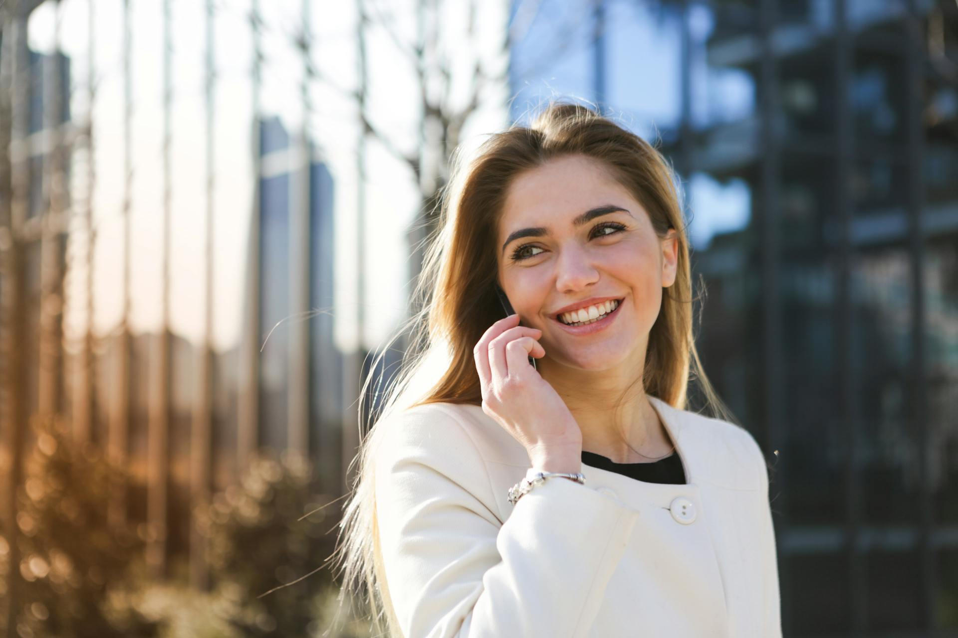 Una mujer sonriente hablando por teléfono | Fuente: Pexels