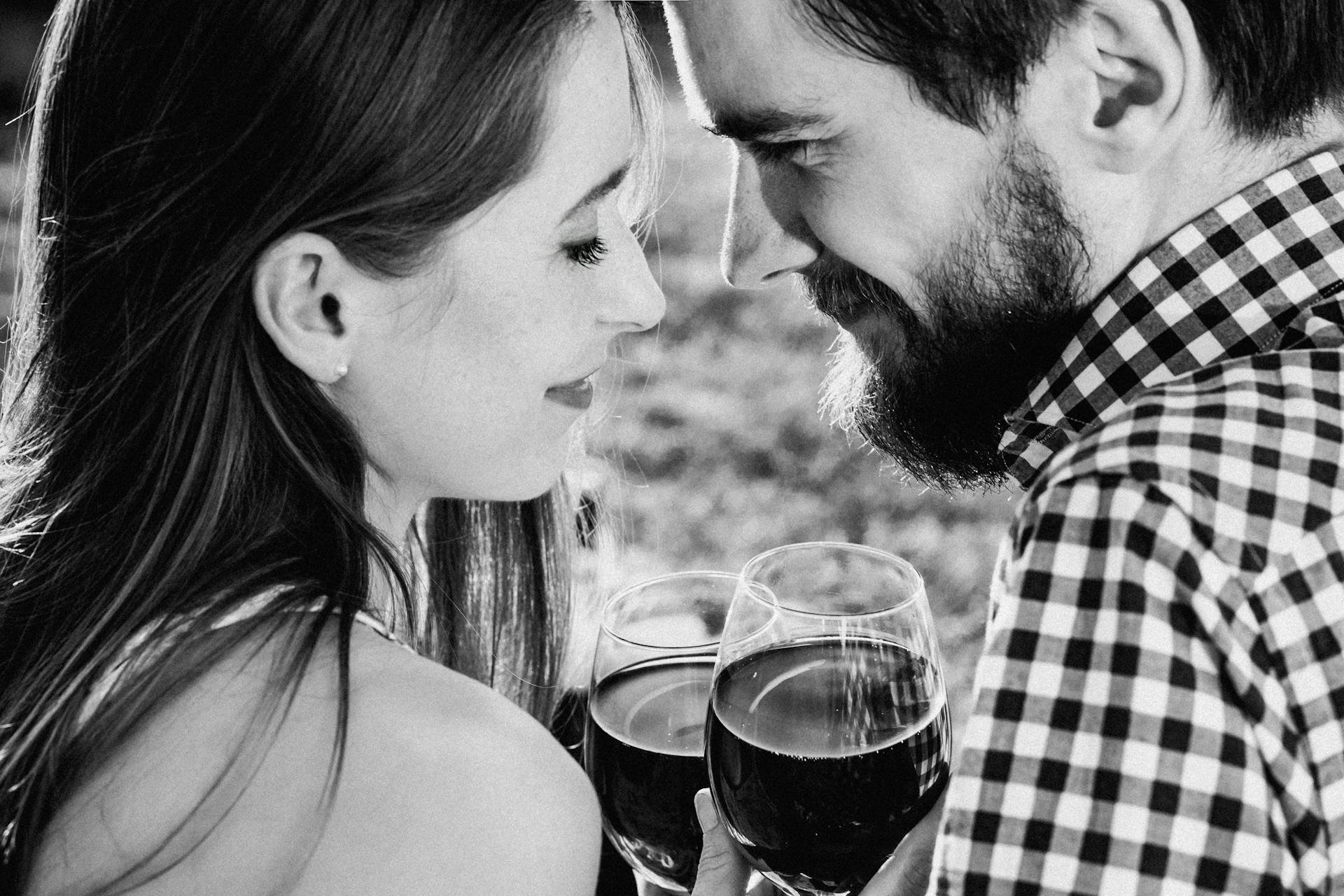 Una pareja de enamorados disfrutando de sus copas al aire libre | Fuente: Pexels