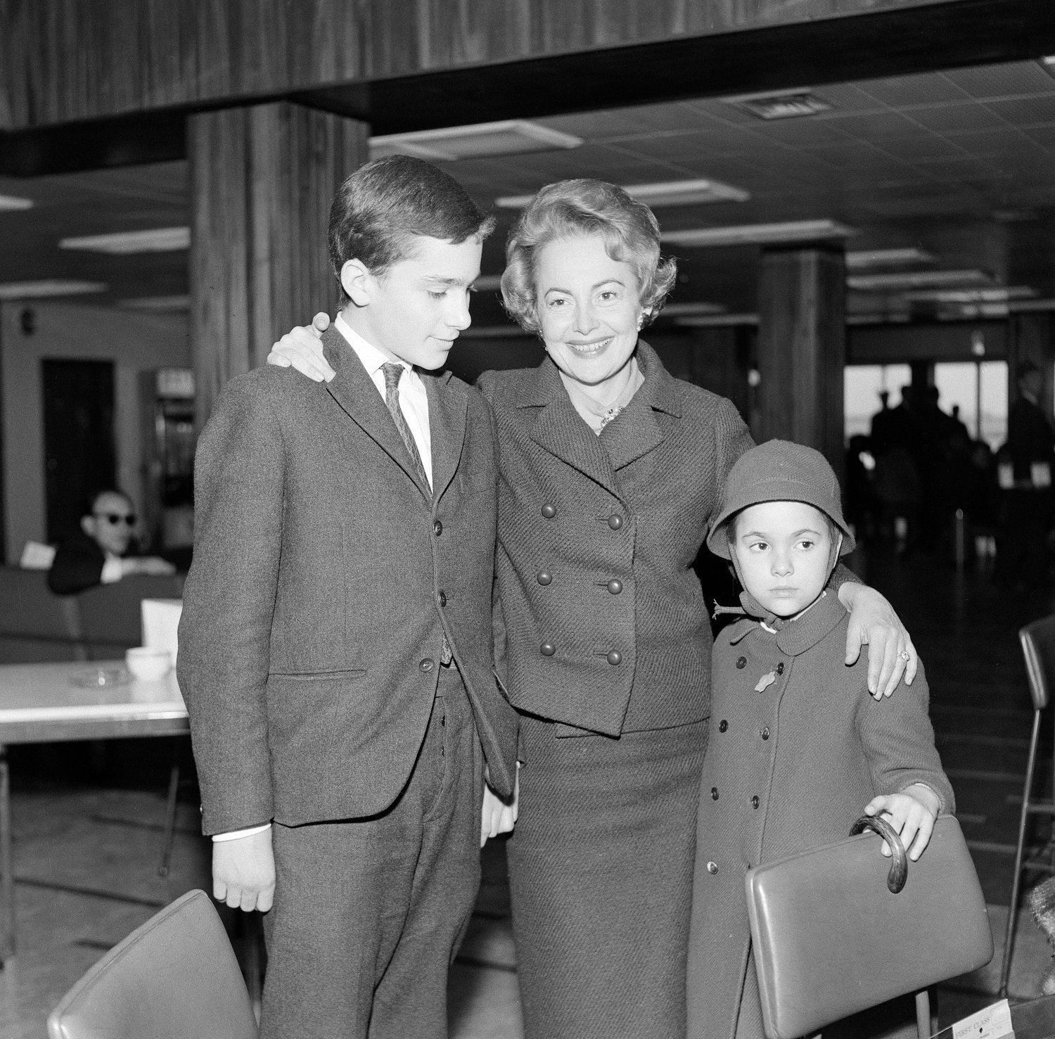 Olivia De Havilland en el aeropuerto de Londres con sus hijos Benjamin y Gisèle esperando un vuelo de regreso a París, el 15 de abril de 1964. | Foto: Getty Images