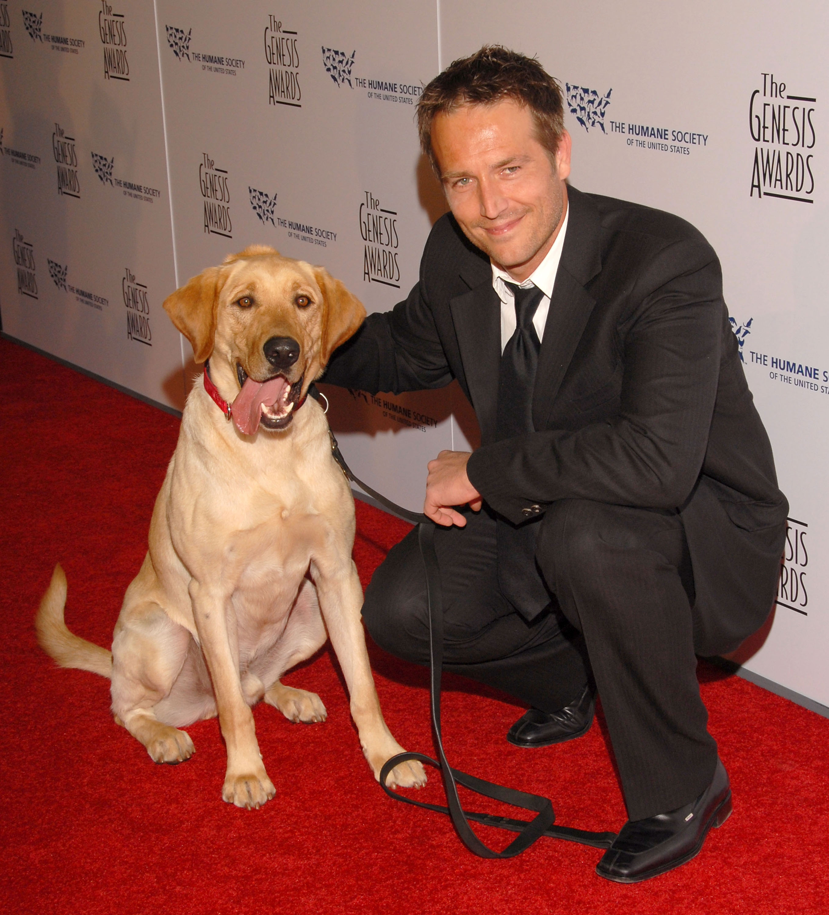 Michael Vartan se agacha junto a un perro en la alfombra roja de los Premios Génesis. Su cálida sonrisa y su presencia afable reflejan su amor por los animales y su estilo discreto a la hora de aparecer en público.
