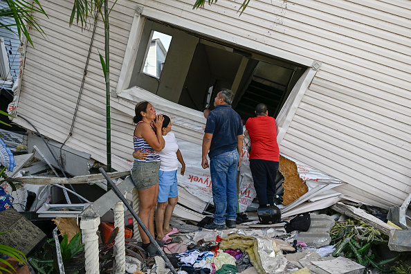 Personas inspeccionan una vivienda dañada tras el terremoto ocurrido en Catia La Mar, estado La Guaira, a unos 30 kilómetros al noroeste de Caracas, el 25 de junio de 2026. Los dos sismos, los más fuertes registrados en Venezuela en más de un siglo, dejaron al menos 164 muertos y destruyeron numerosos edificios cerca de la capital, donde los habitantes continuaban buscando a sus familiares desaparecidos.