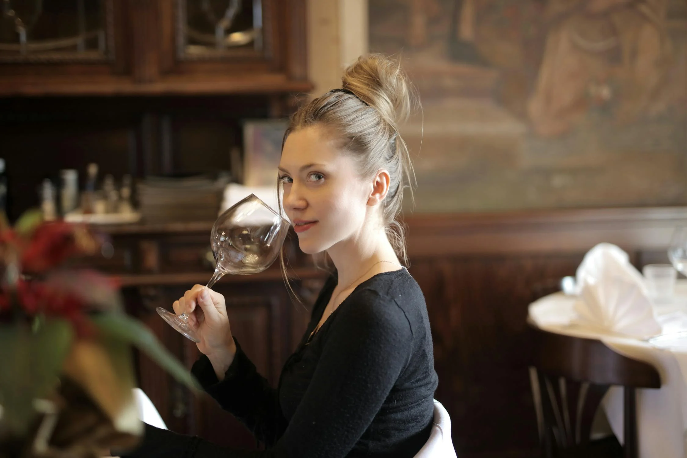 Una mujer sonriente mirando a su lado en un restaurante | Fuente: Pexels