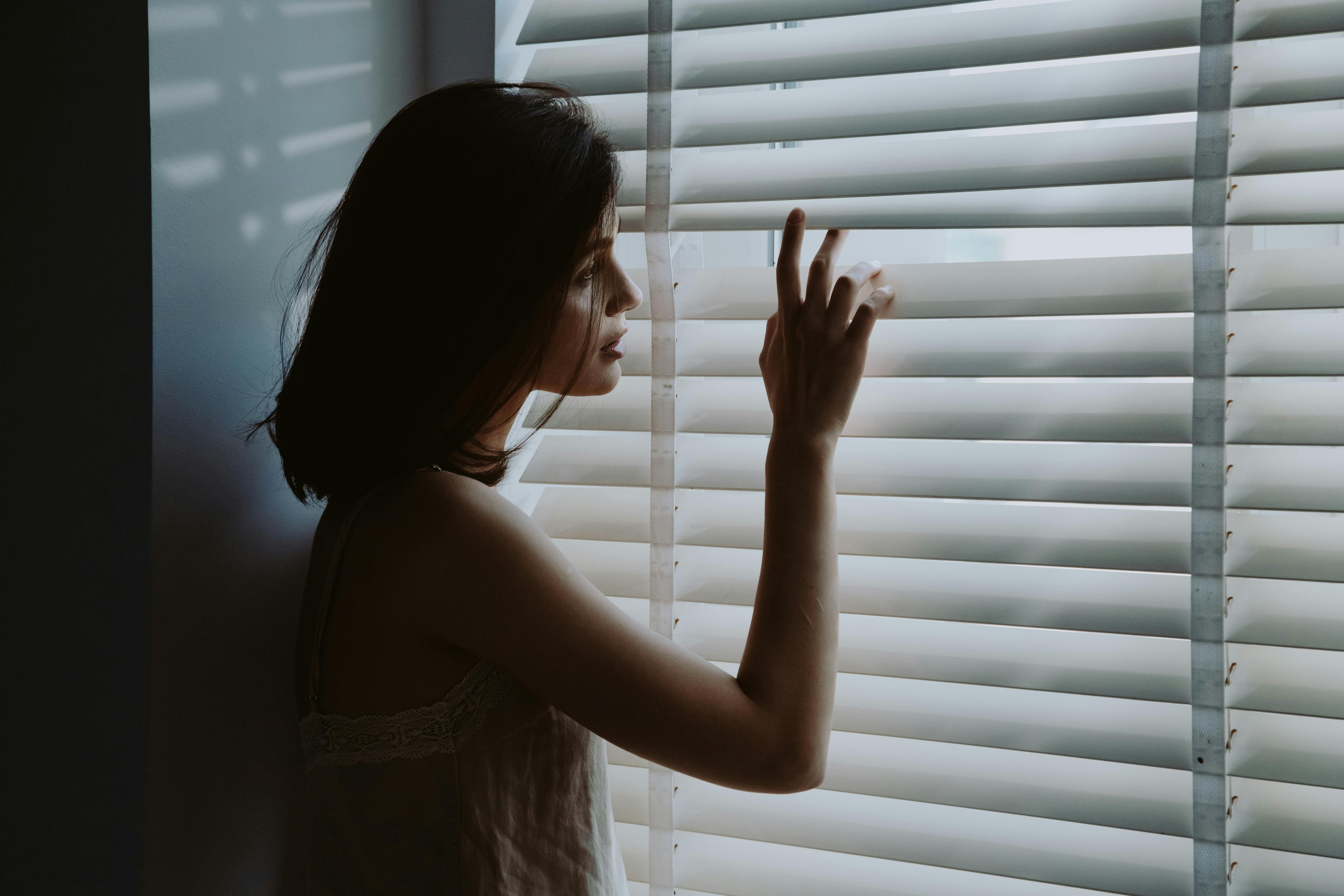 Una mujer mirando por la ventana | Fuente: Pexels