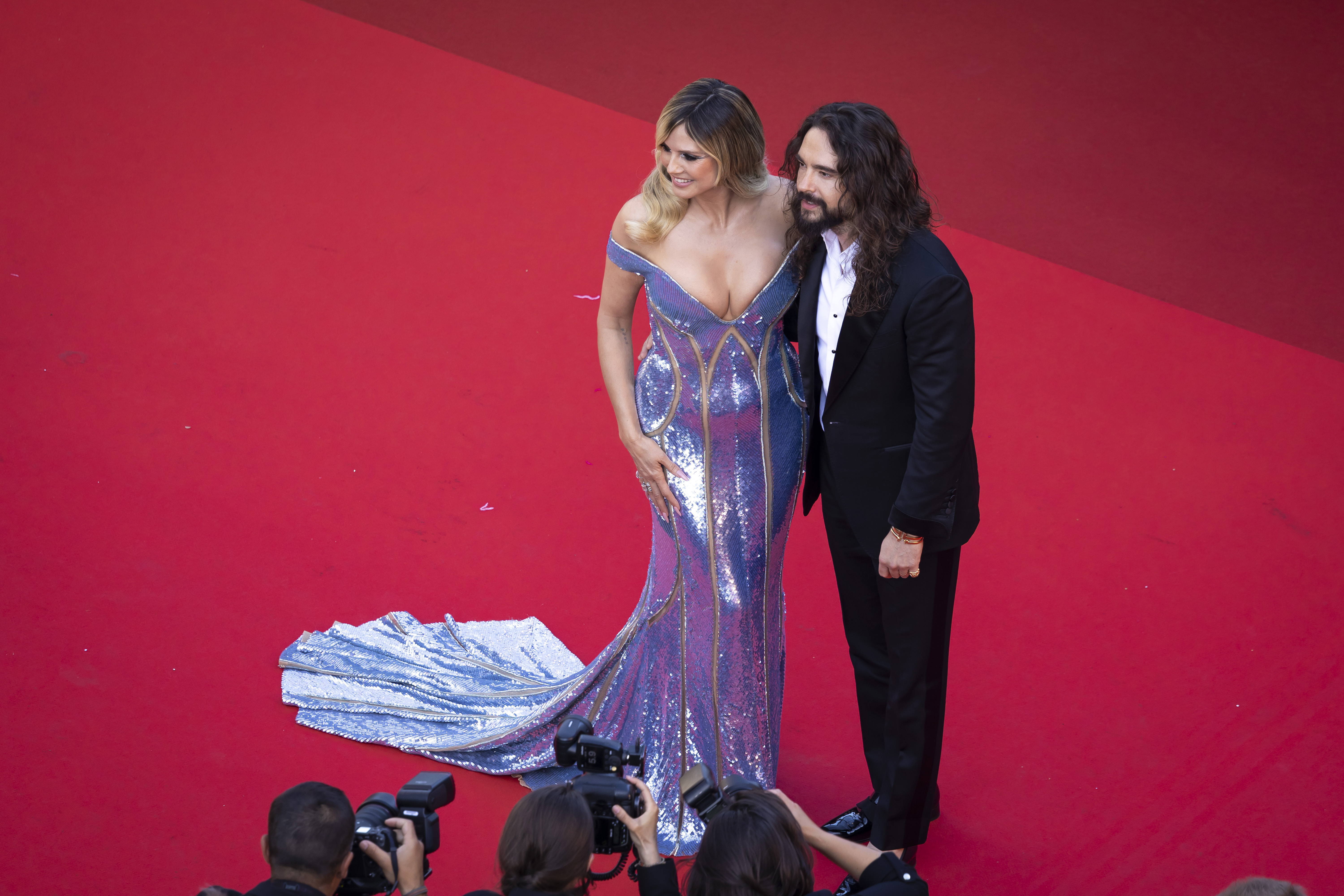 En una toma aérea, Kaulitz y Klum están uno al lado del otro, complementándose perfectamente tanto en atuendo como en aura. Su elegancia coordinada y su presencia compartida crean una imagen impactante de armonía, belleza y poder de estrella.