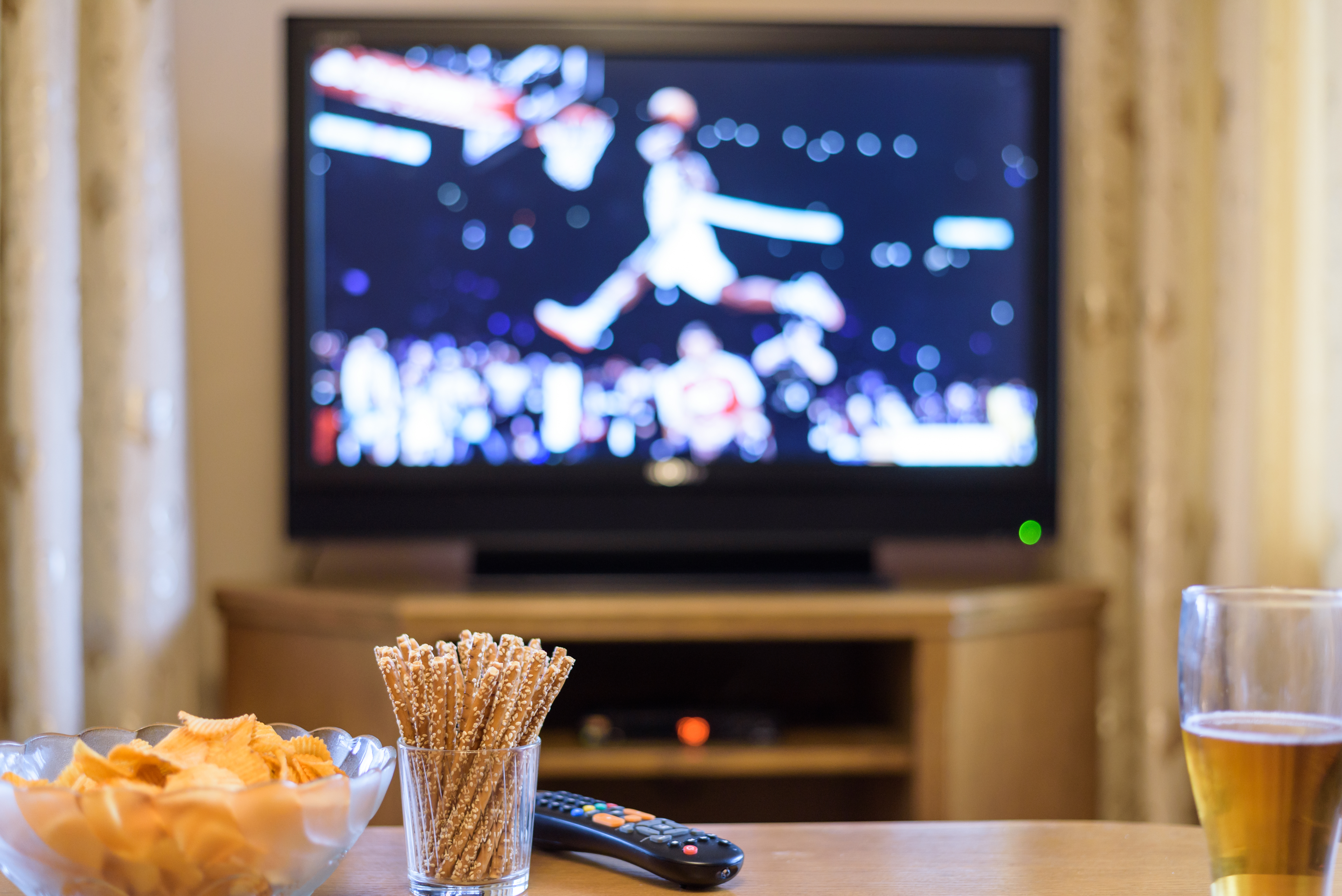 Partido de baloncesto en la TV y aperitivos | Foto: Shutterstock