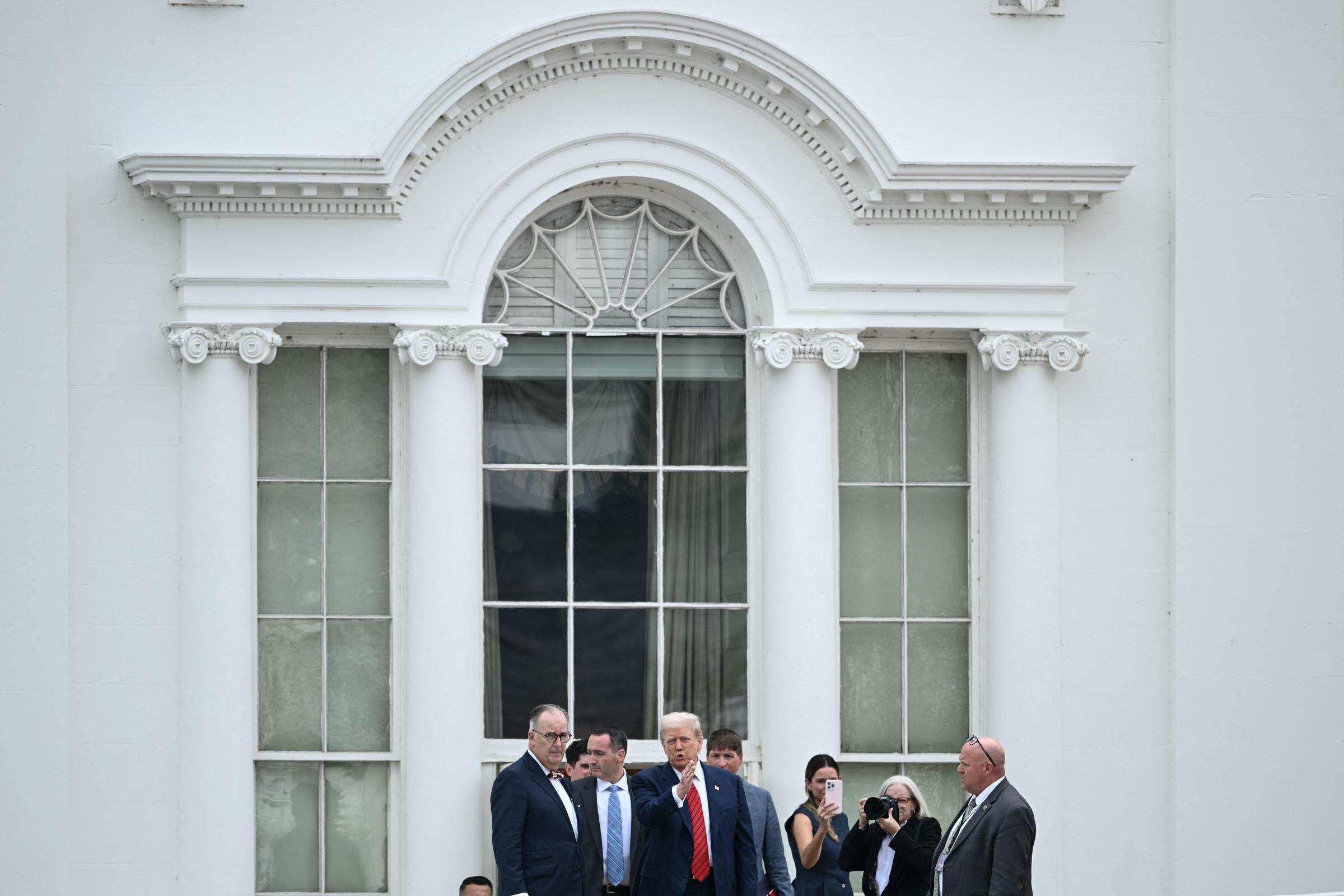 De pie junto a sus asesores en el techo del ala oeste de la Casa Blanca, el presidente Donald Trump parecía estar concentrado en una animada conversación durante su inesperado recorrido por el techo.