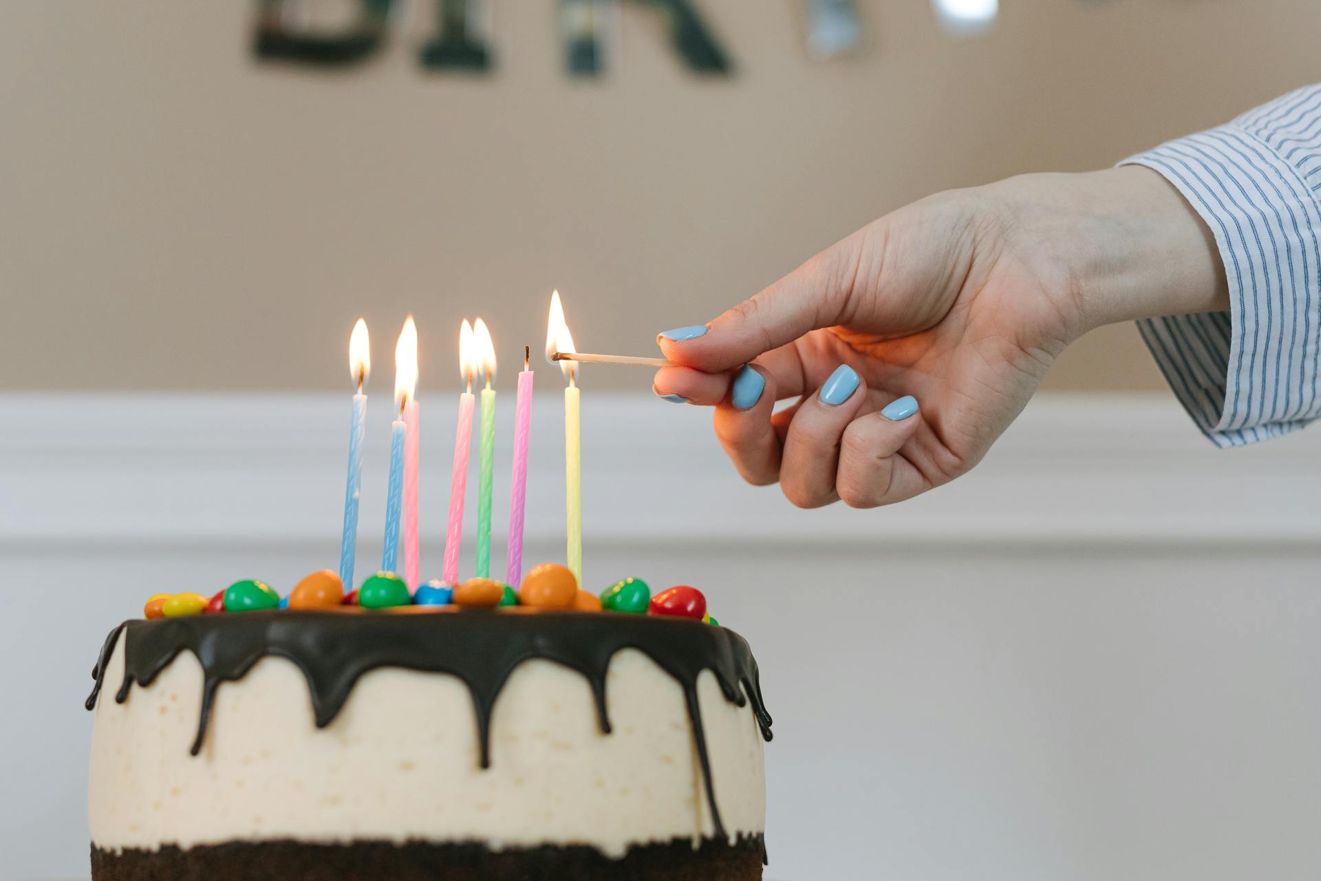 Una mujer encendiendo velas en un Pastel | Fuente: Pexels
