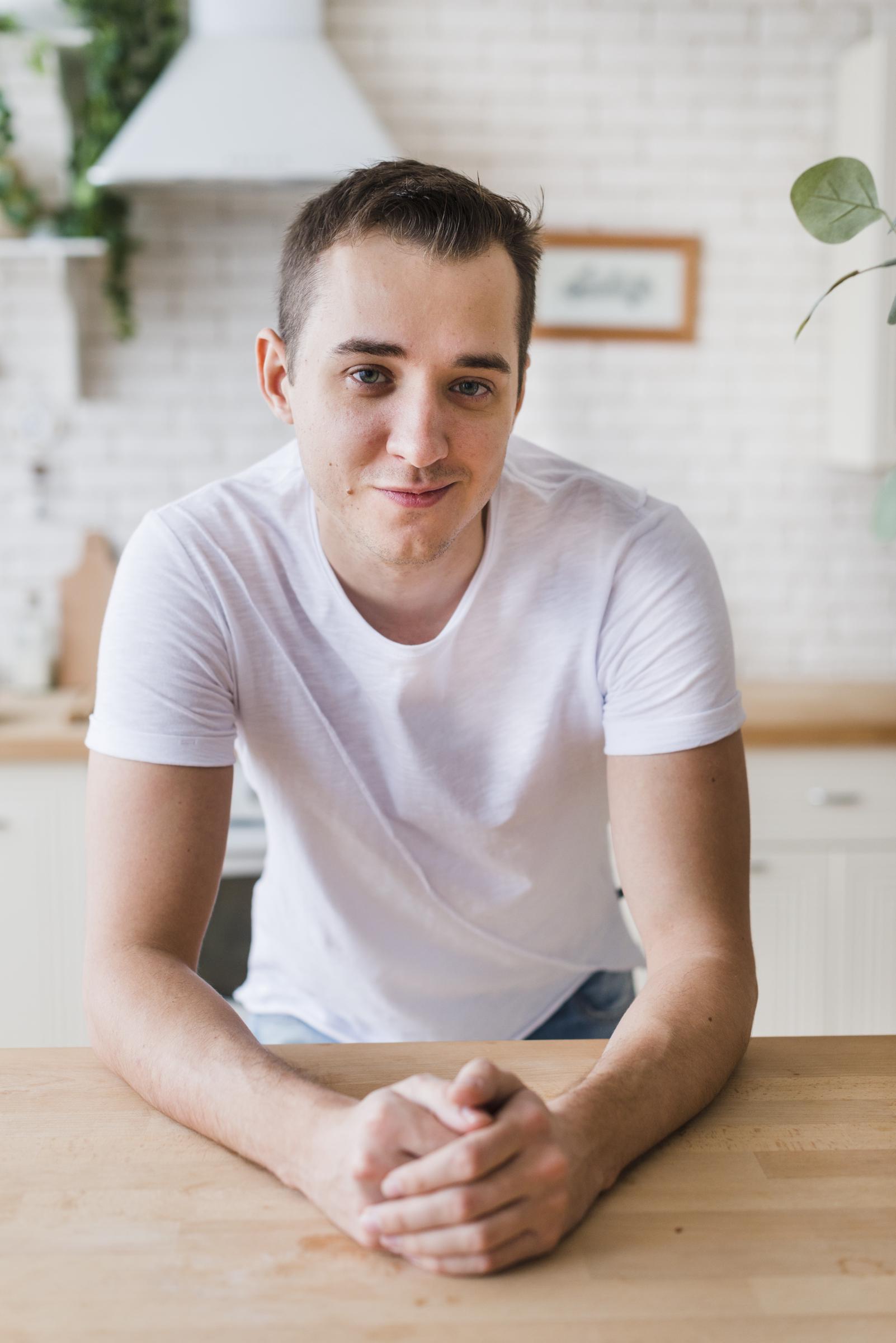 Un hombre empinando los dedos y sonriendo | Fuente: Freepik