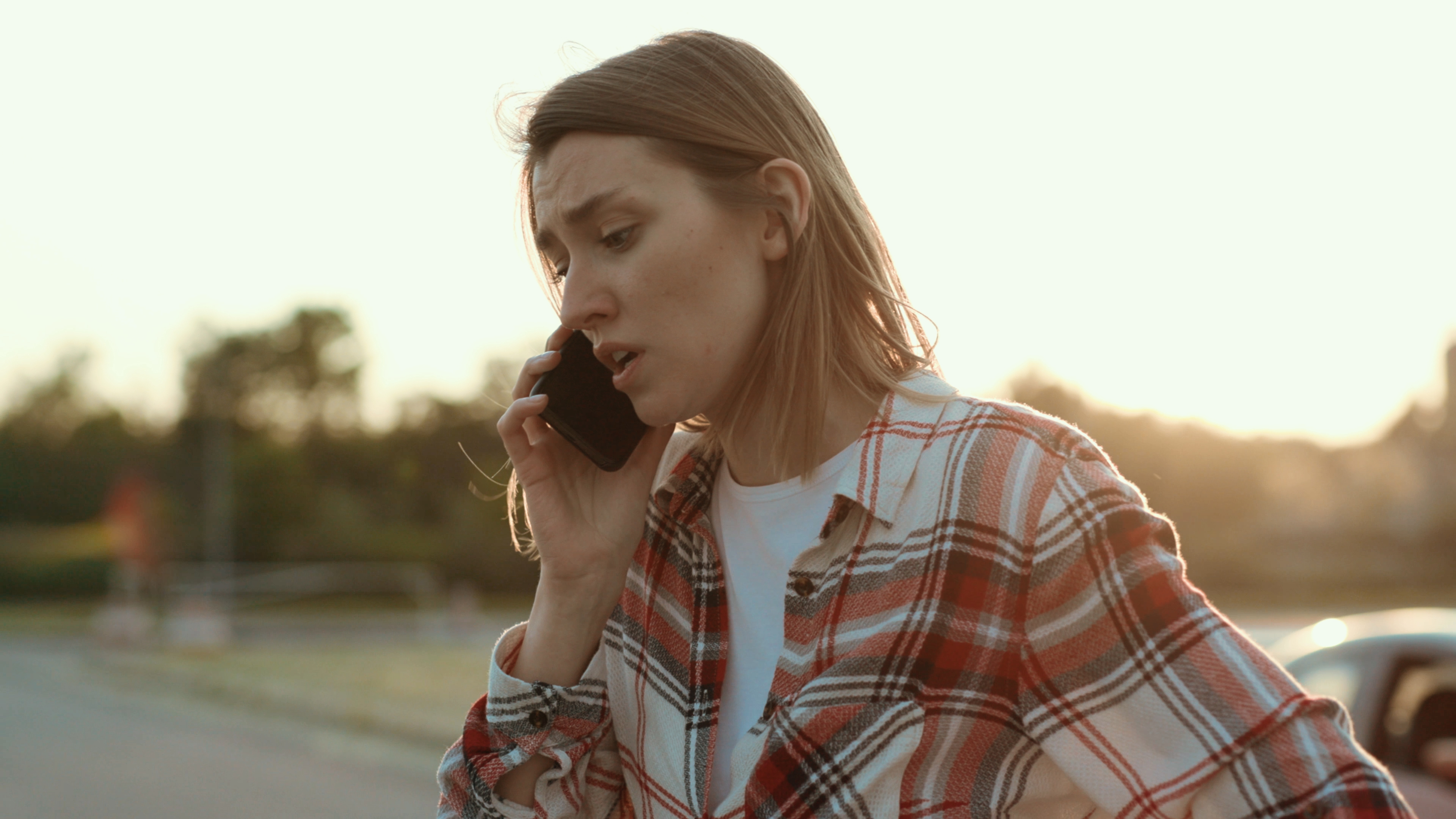 Joven decepcionada hablando por teléfono de pie en la calle. | Fuente: Shutterstock