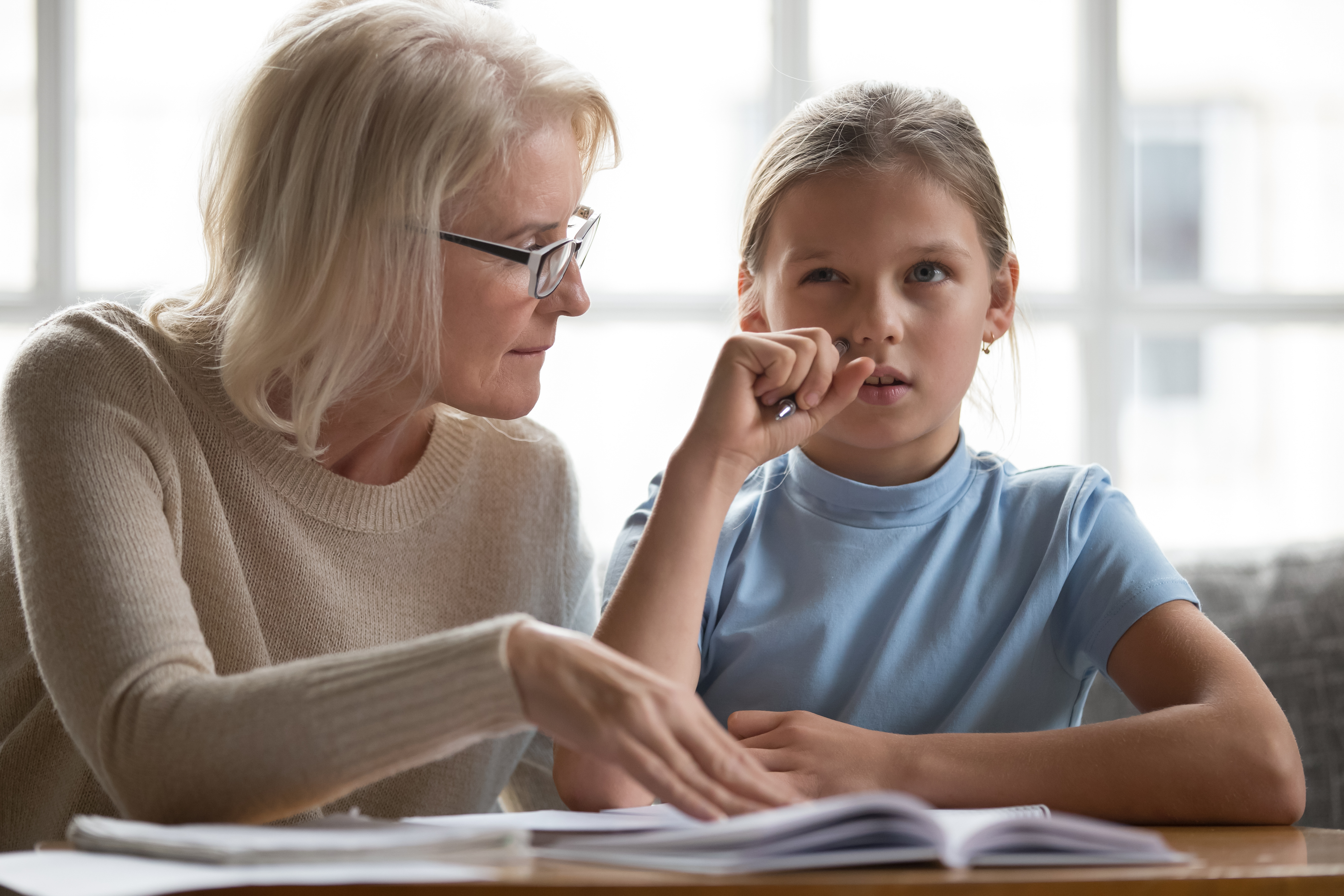 Mujer mayor enseñando a una niña | Foto: Shutterstock