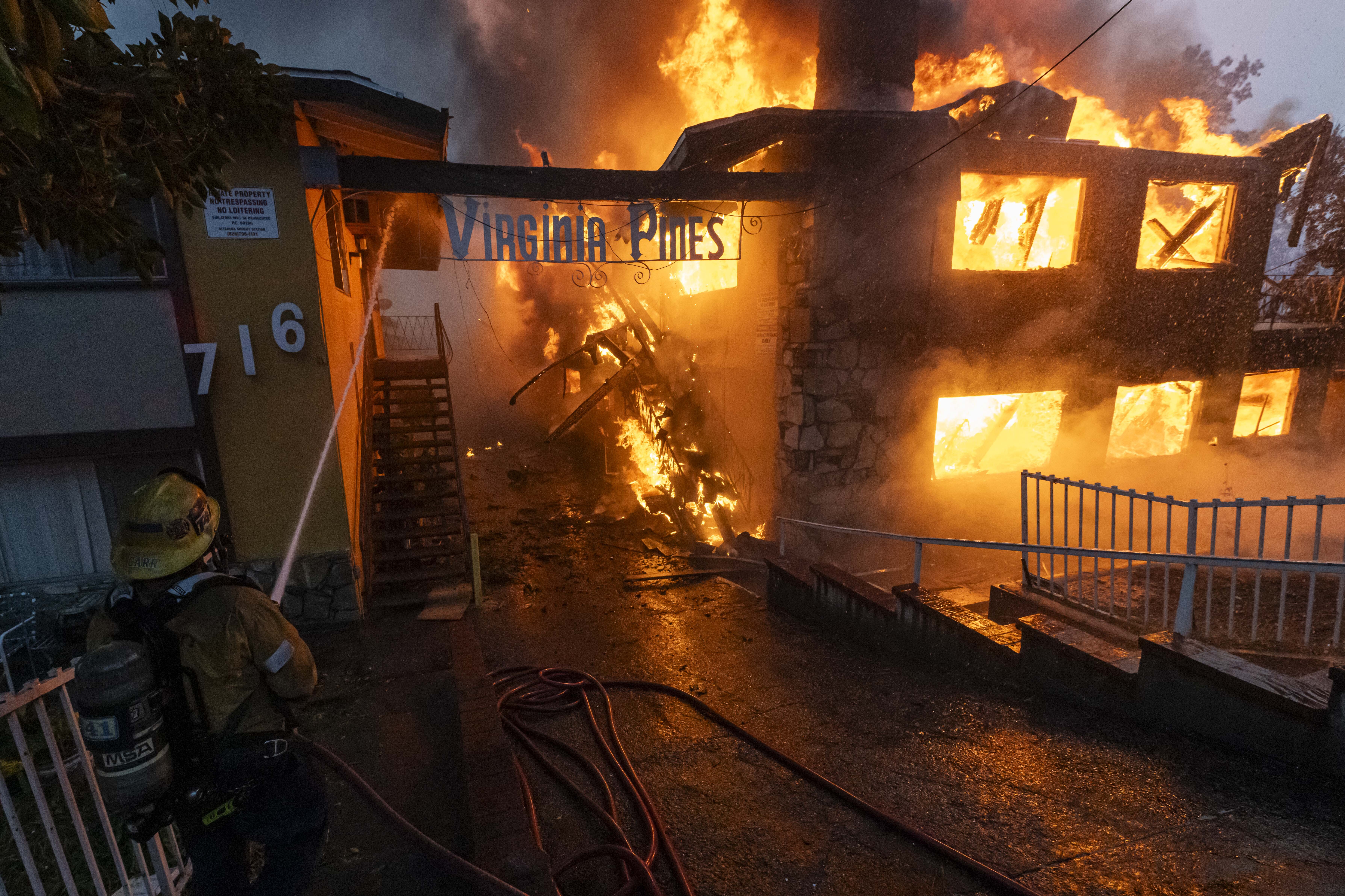 Un bombero del LAFD limpiando con una manguera un complejo de apartamentos en llamas del incendio de Eaton en Altadena, California, el 8 de enero de 2025 | Fuente: Getty Images