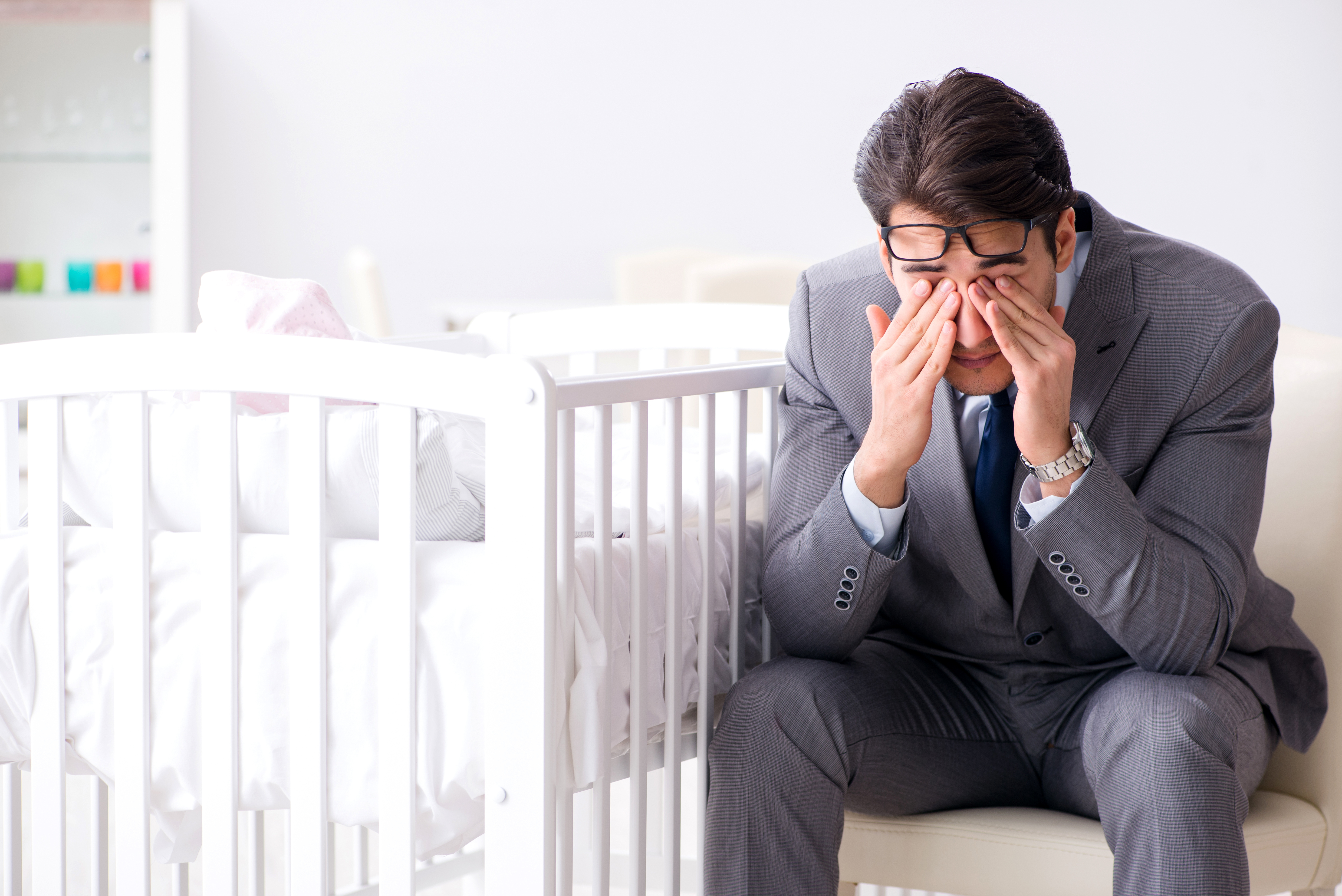 Hombre emocionalmente comprometido sentado junto a una cuna vacía. | Foto: Shutterstock