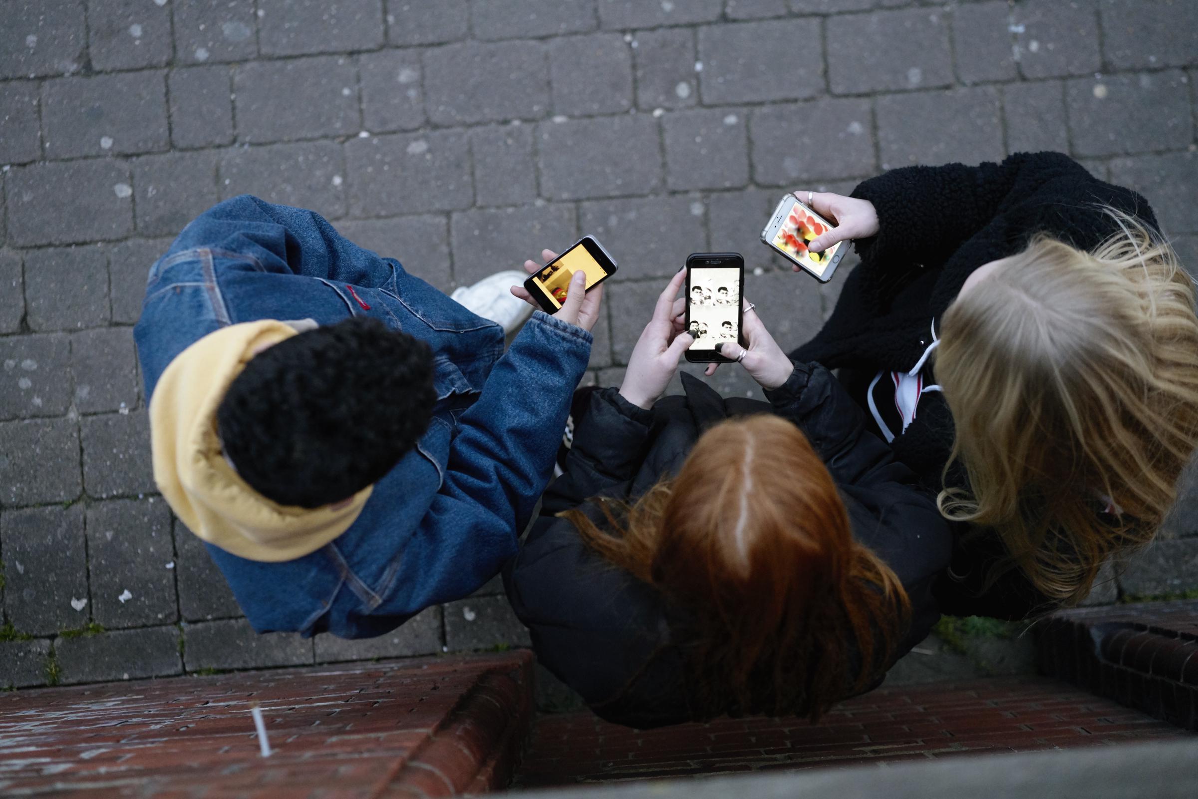Un grupo de amigos hablando por teléfono | Fuente: Getty Images