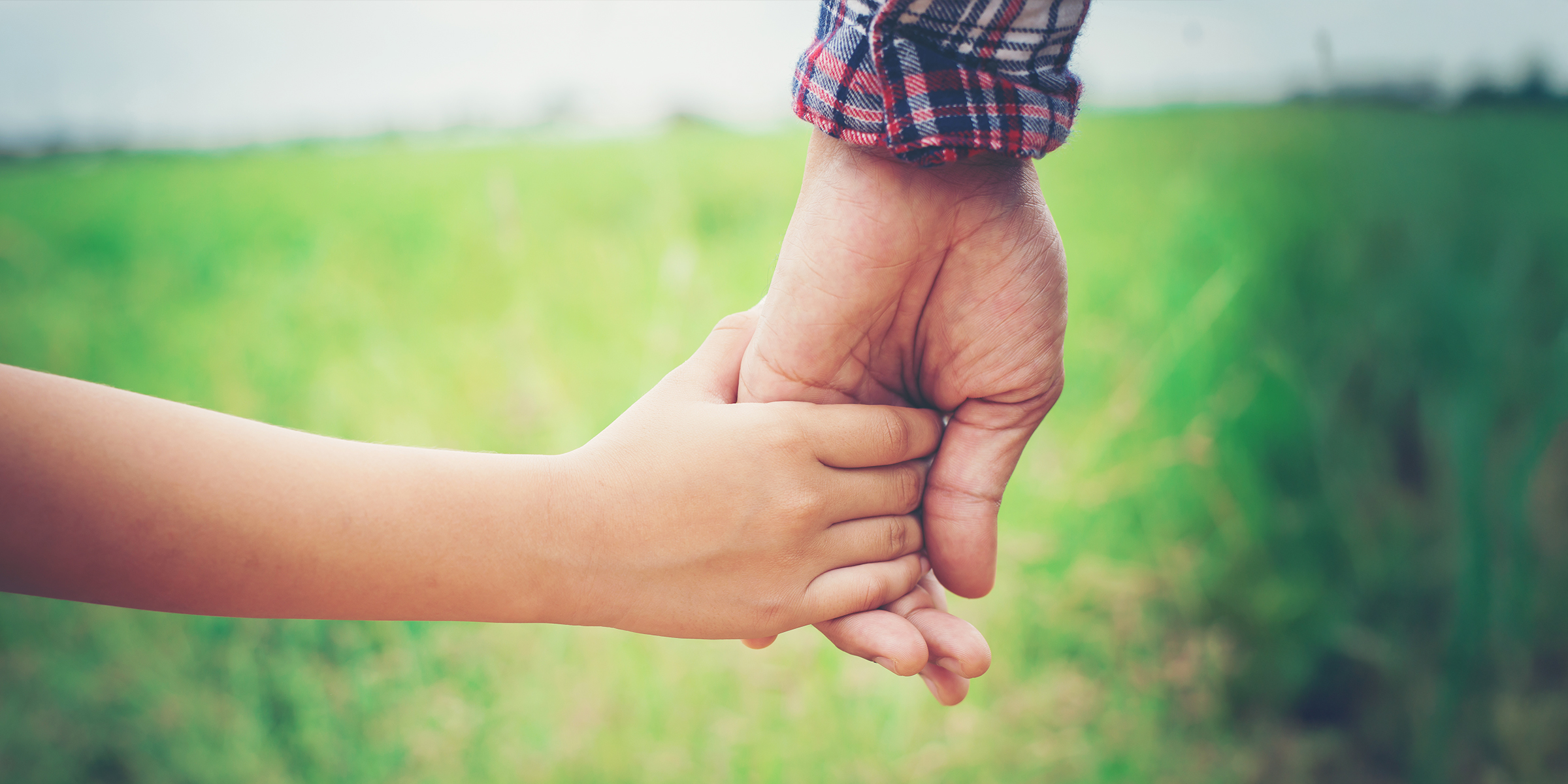 Un niño cogido de la mano de un hombre | Fuente: Shutterstock