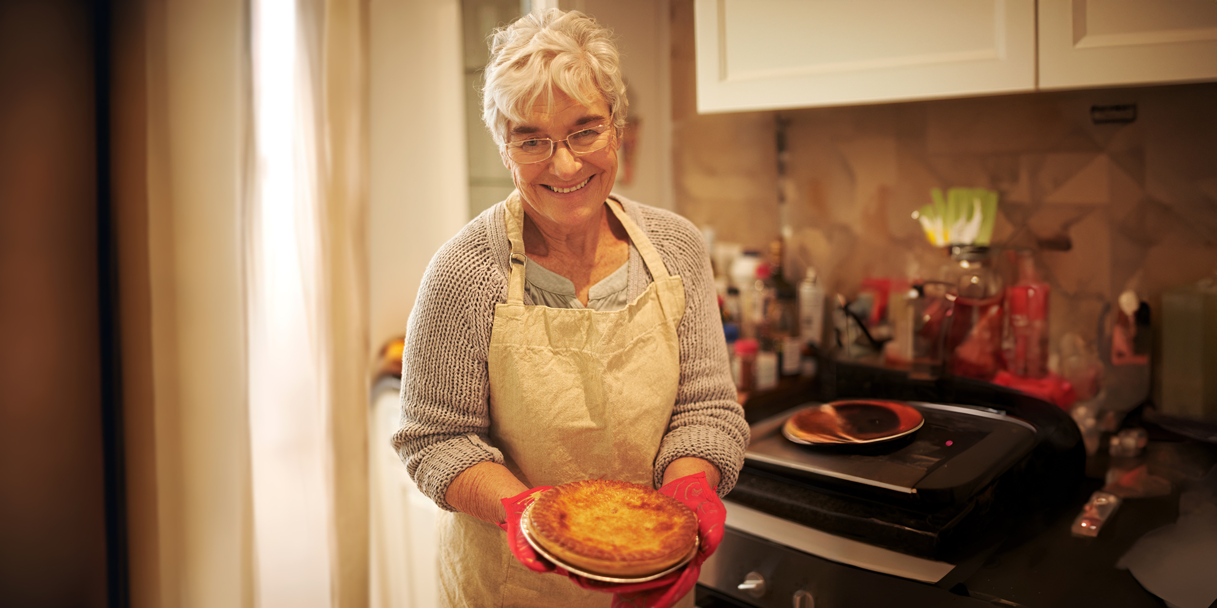 Una mujer feliz sosteniendo una tarta | Fuente: Shutterstock