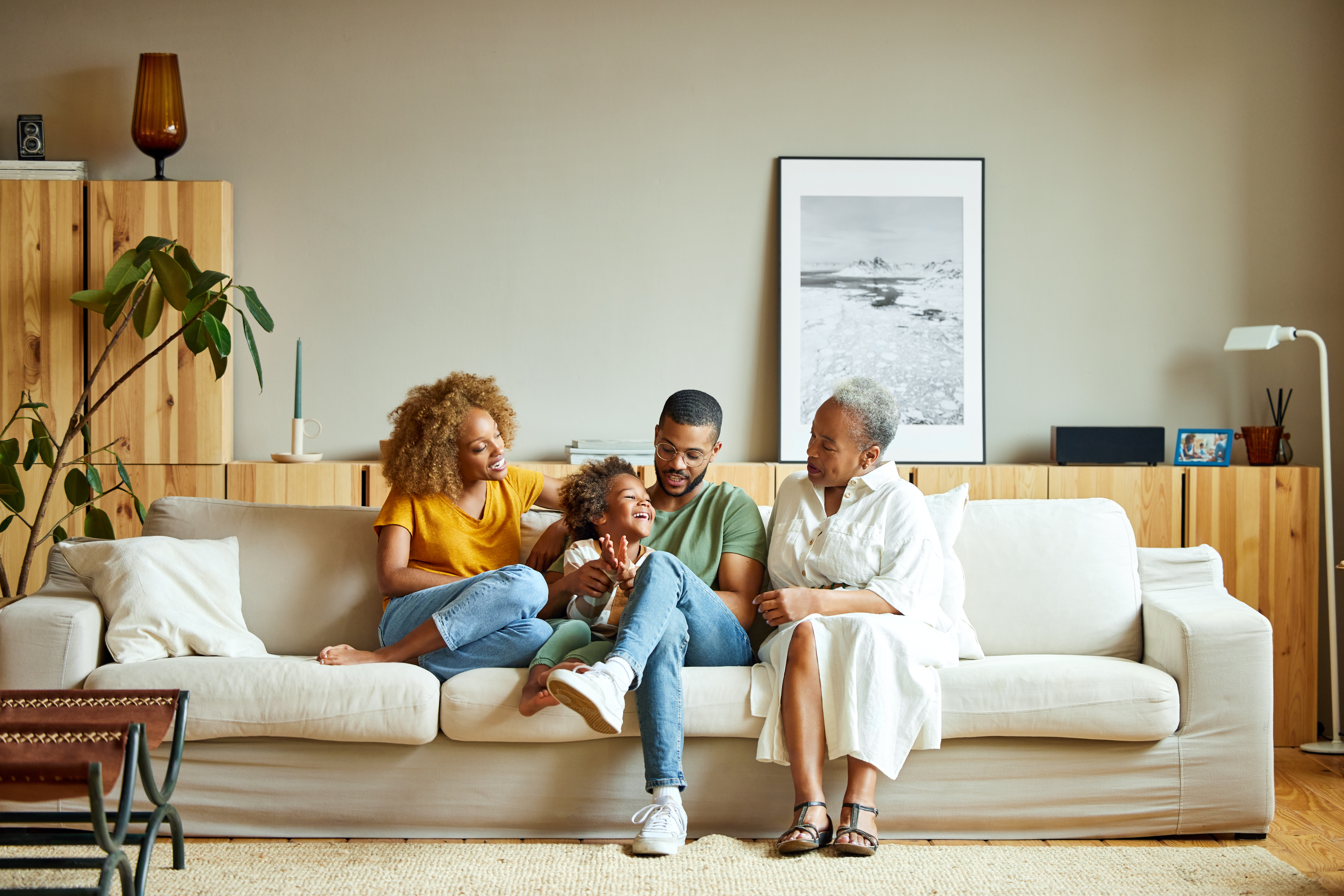 Familia afroamericana feliz disfrutando en el salón | Foto: Getty Images