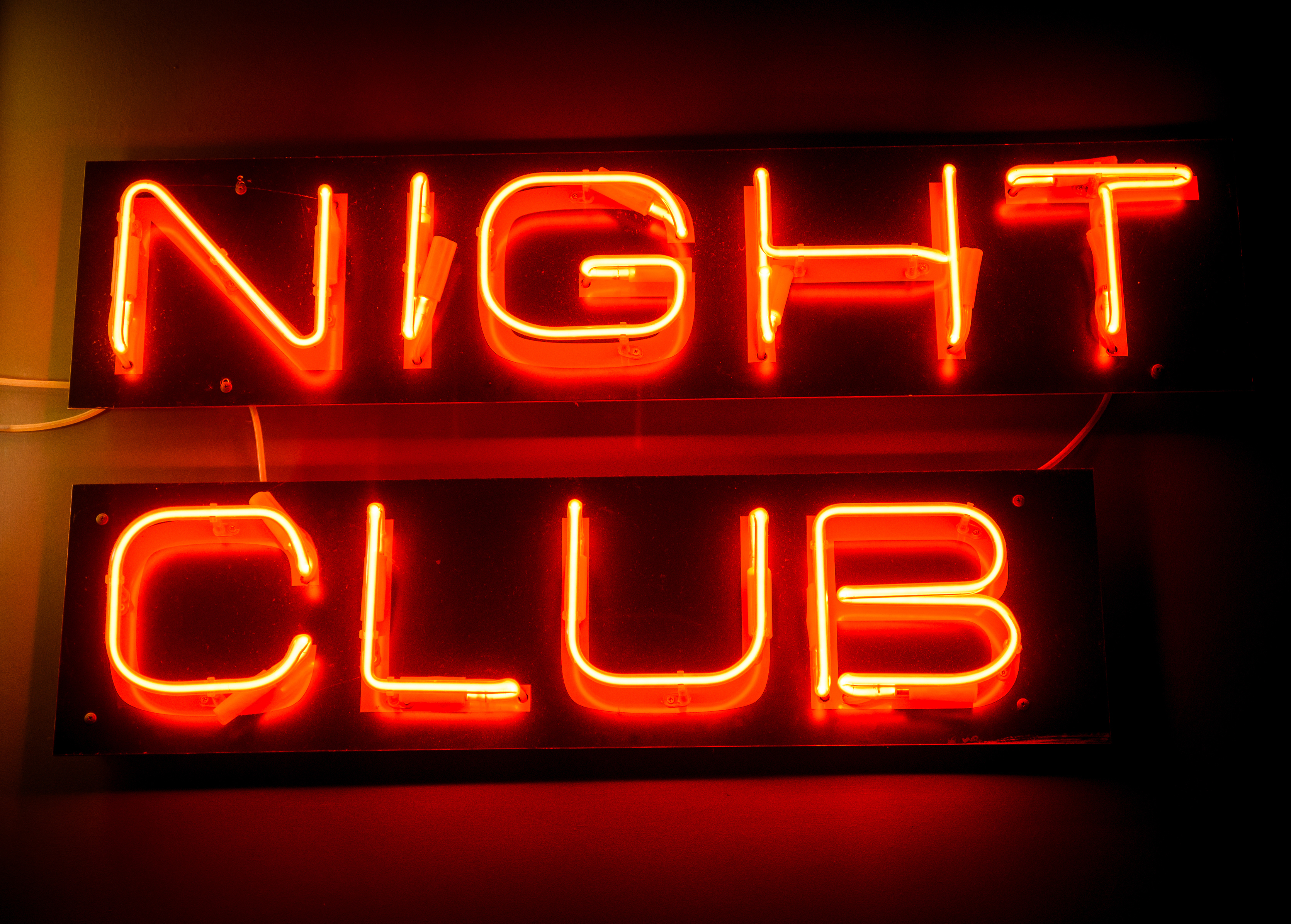 Cartel de neón de discoteca colgado en la pared. | Fuente: Shutterstock