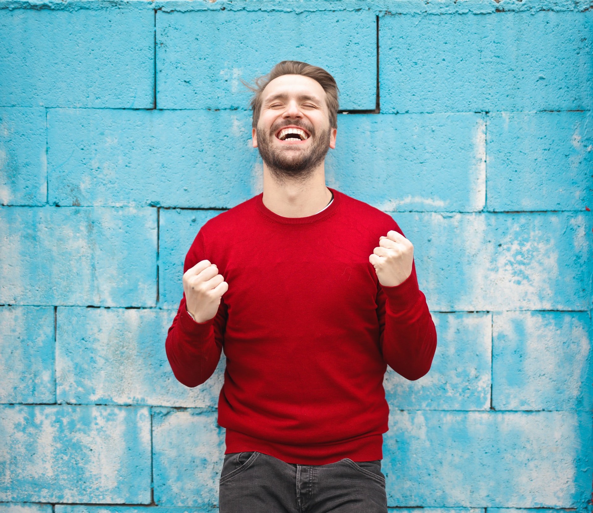 Hombre sonriendo con gesto triunfal. | Foto: Unsplash