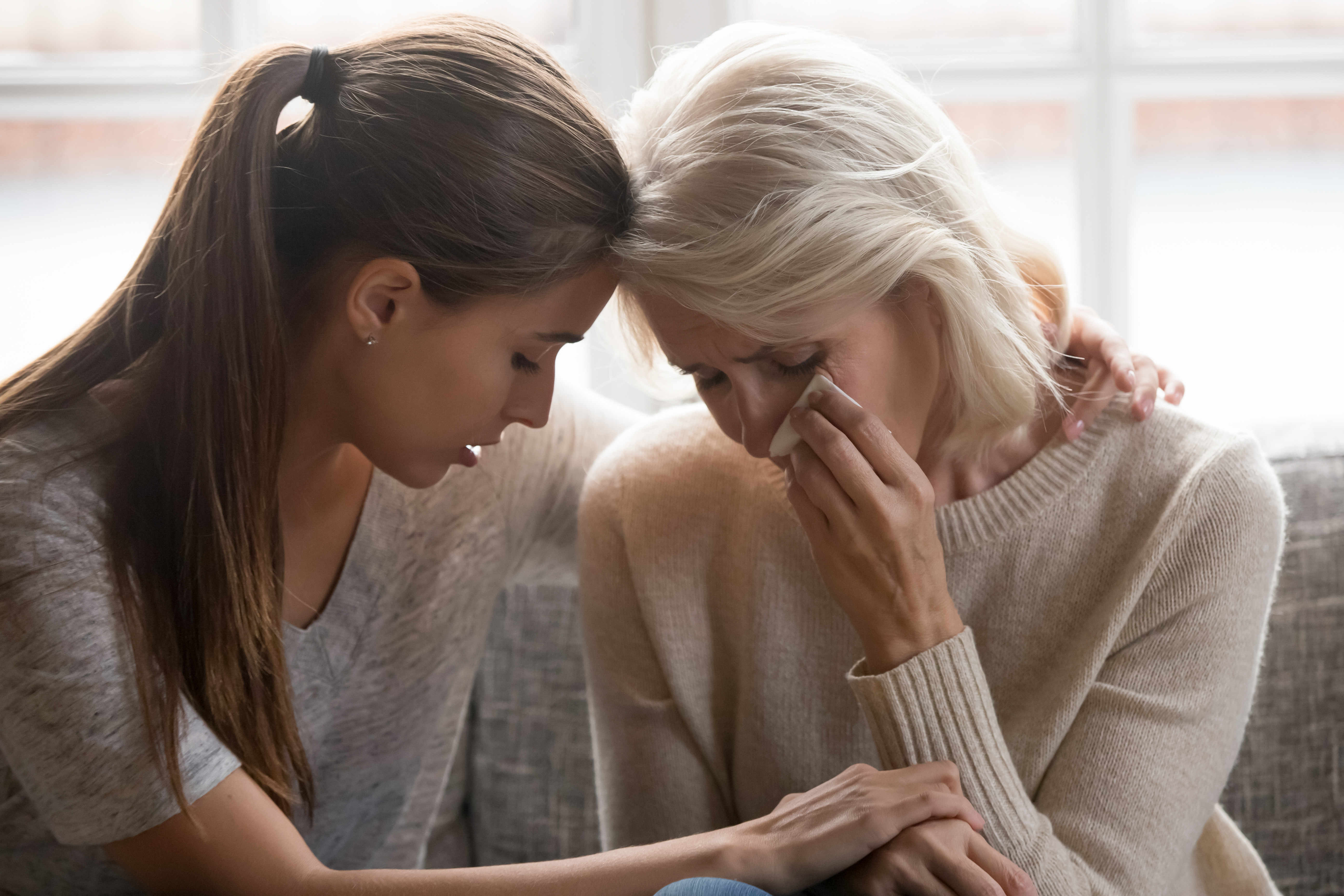 Hija adulta compadeciéndose de su madre | Fuente: Shutterstock