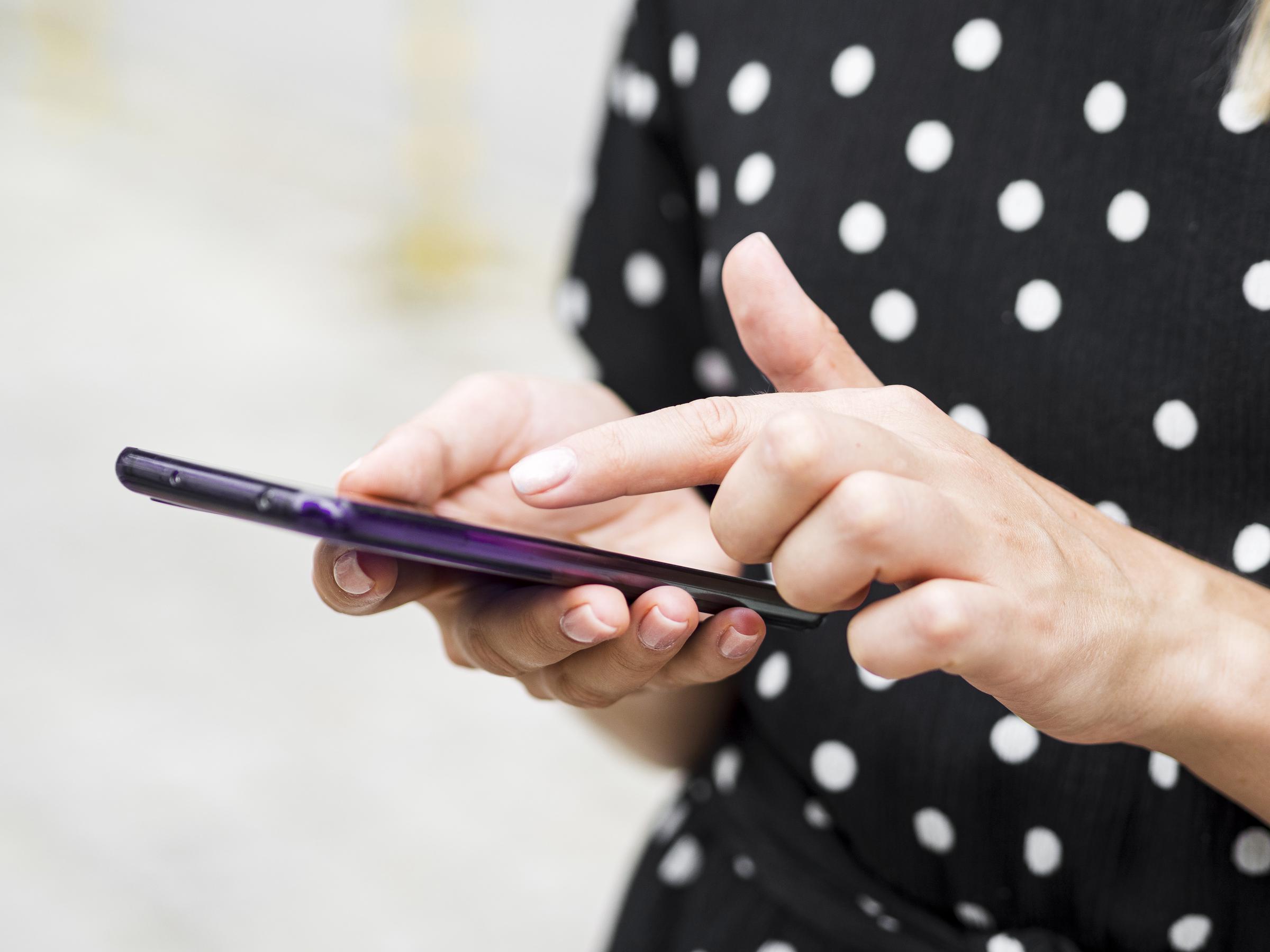 Una joven leyendo los textos de su teléfono | Fuente: Freepik