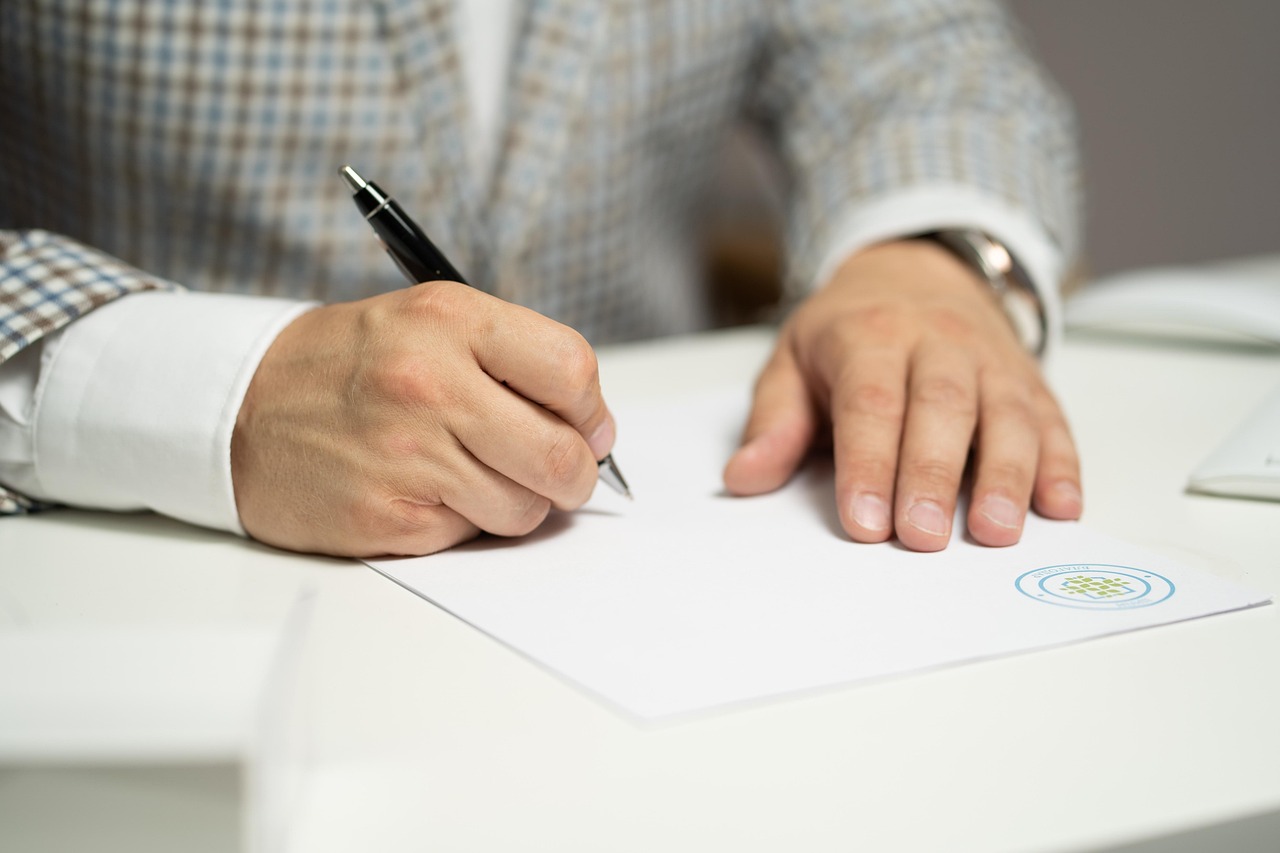 Un hombre firmando un documento | Fuente: Pixabay