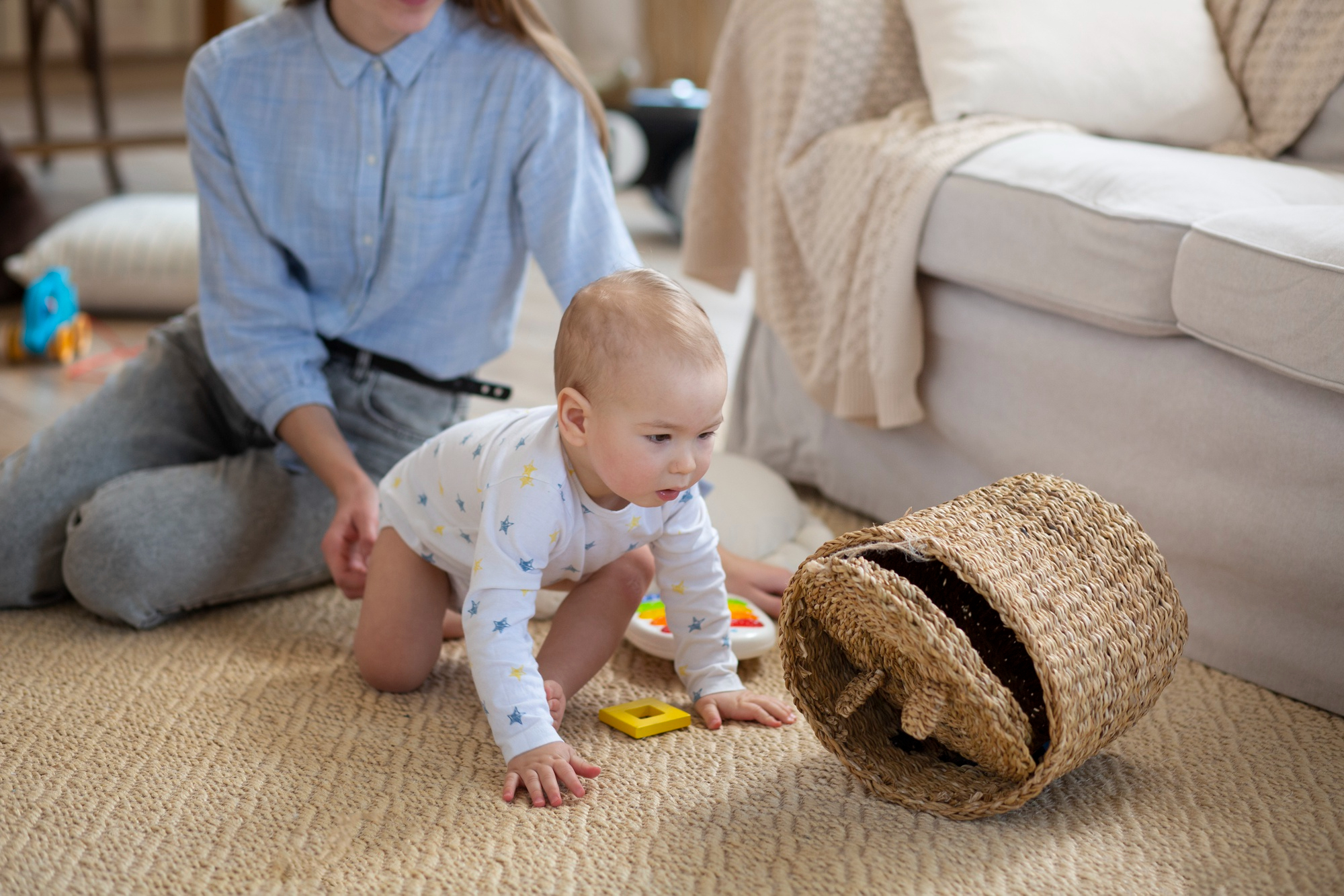 Primer plano de una niñera sujetando a un bebé que gatea en una habitación | Fuente: Freepik