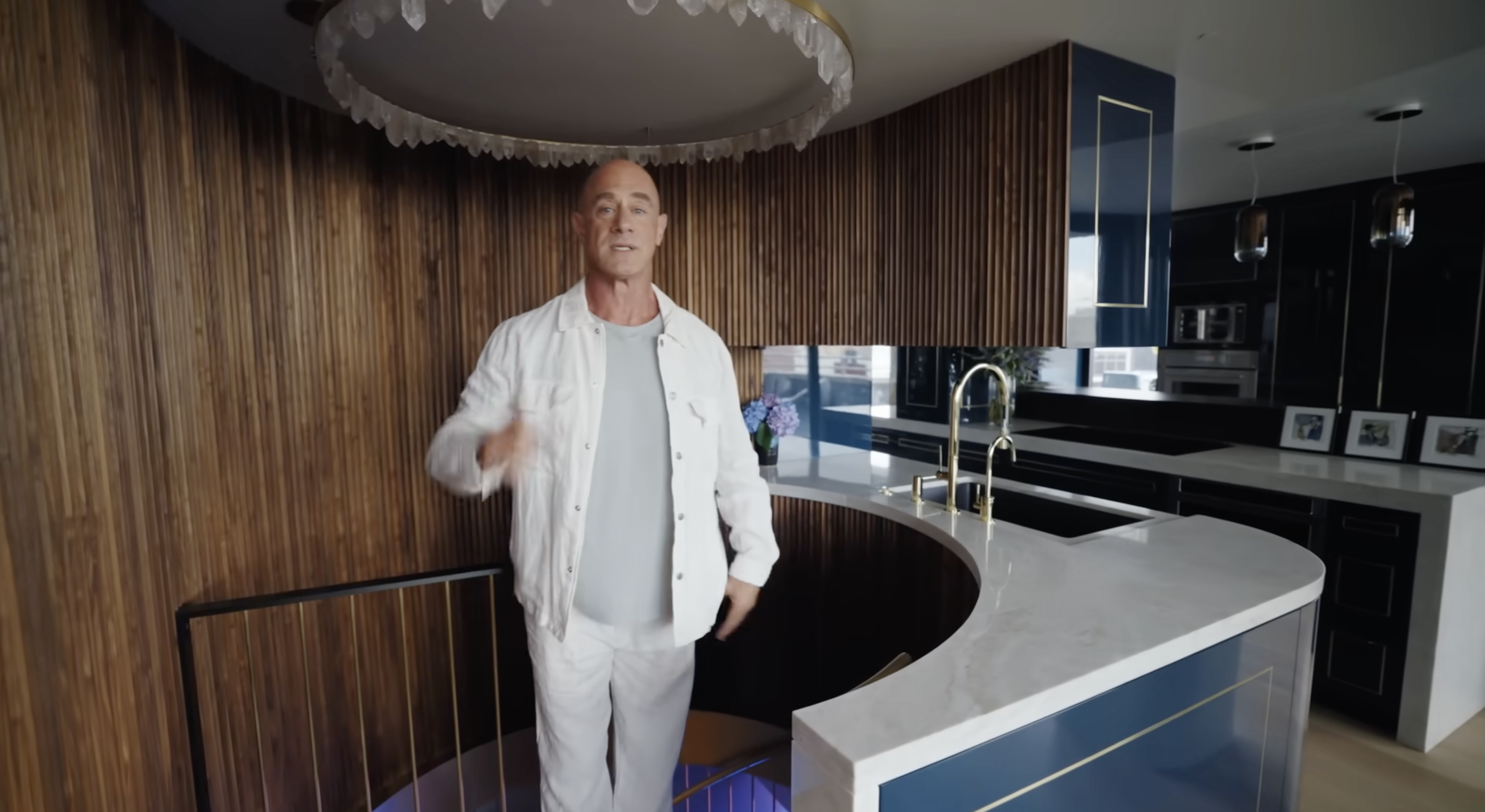 Christopher Meloni junto a su escalera de caracol que conduce a las habitaciones | Fuente: YouTube/Architectural Digest