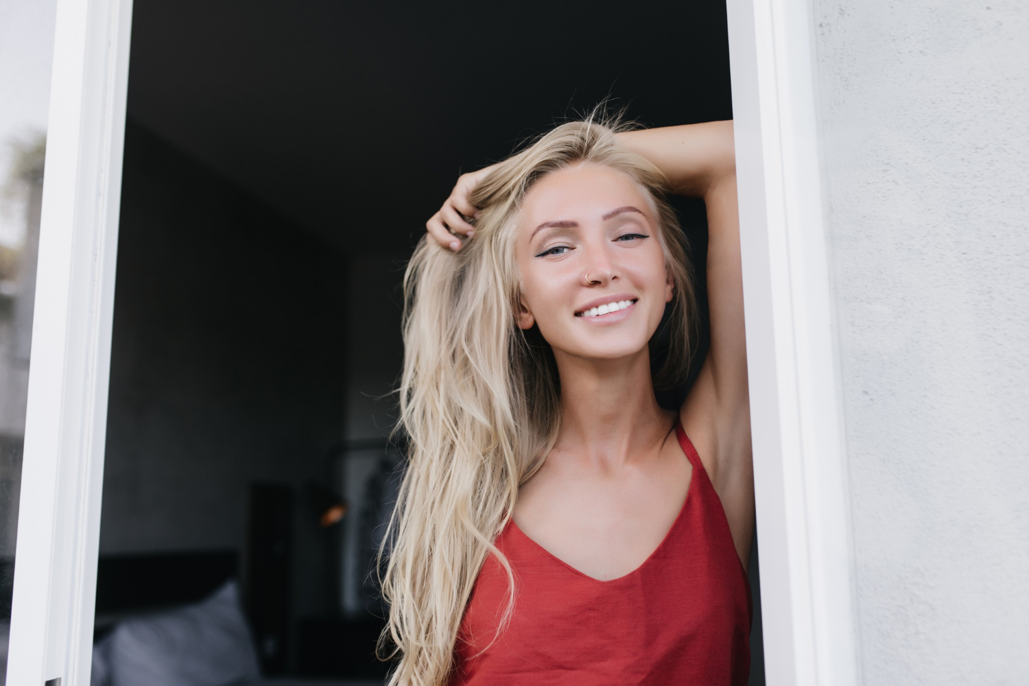 Una mujer sonriente de pie en la puerta | Fuente: Freepik
