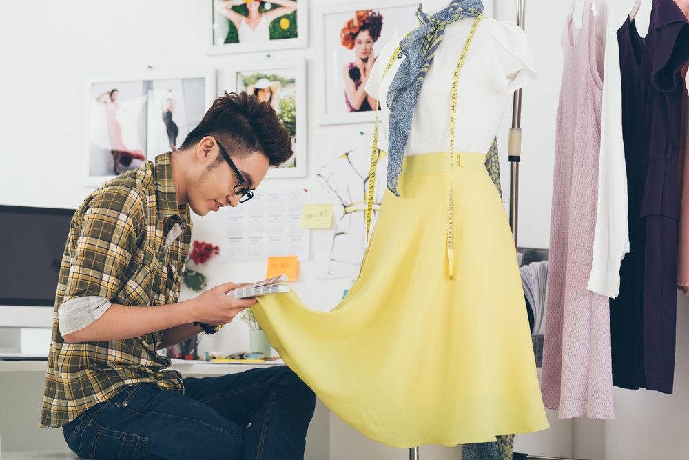 Sastre realizando ajustes a una falda de color amarillo. | Foto: Shutterstock