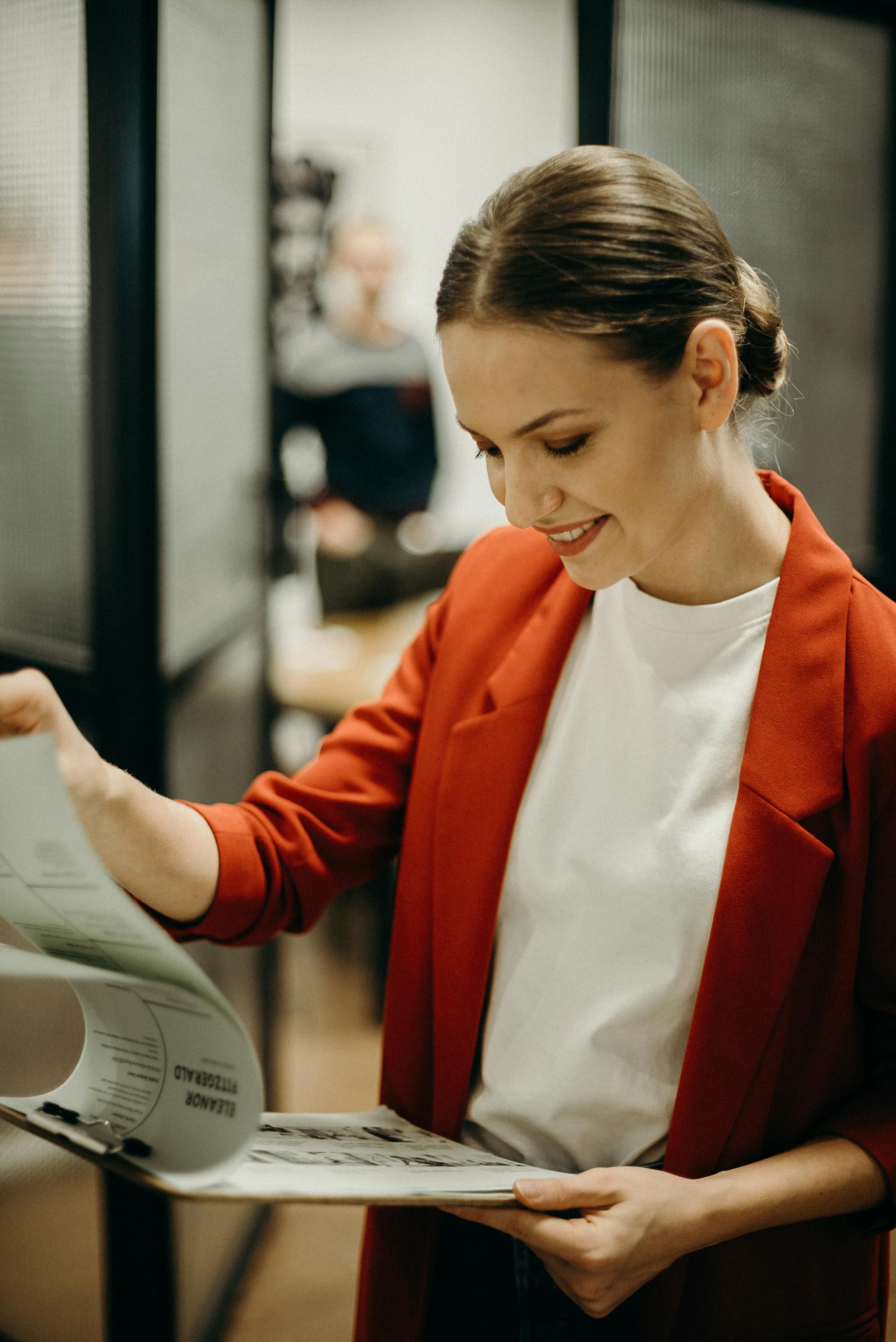 Una mujer sujetando un portapapeles | Fuente: Pexels