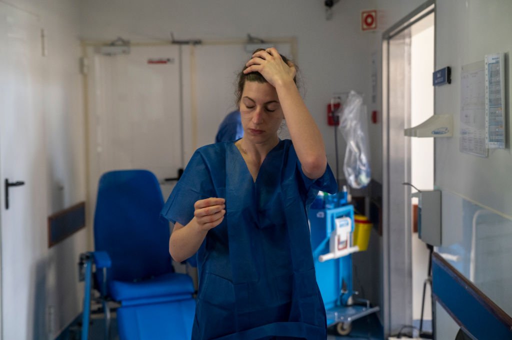 Una enfermera técnica, que aún muestra las marcas de su máscara facial, hace gestos mientras abandona un área estéril del sector de cuidados intensivos para pacientes con COVID-19 en el Hospital de Santa María el 2 de abril de 2020 en Lisboa, Portugal. I Foto: Getty Images