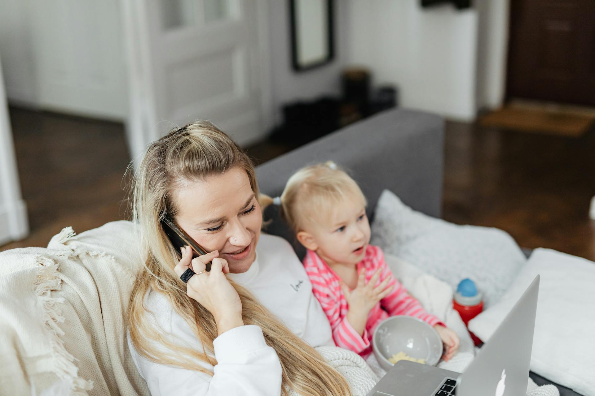 Una mujer hablando por teléfono mientras cuida de su hija | Fuente: Pexels