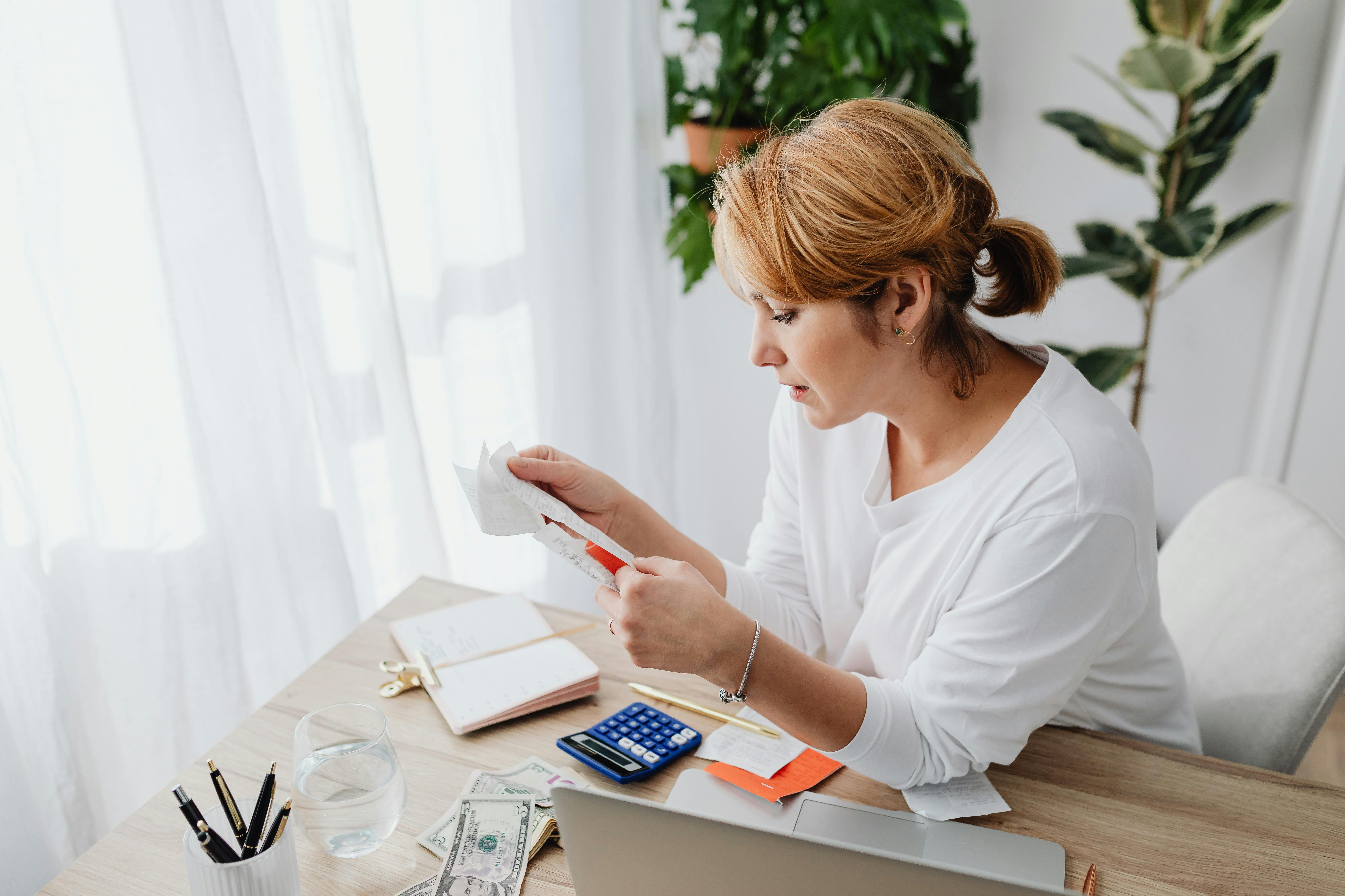 Una mujer mirando un papel sobre un escritorio | Fuente: Pexels