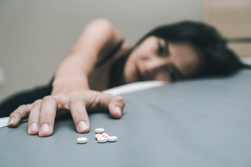 Mujer con pastillas en la cama. | Foto: Shutterstock