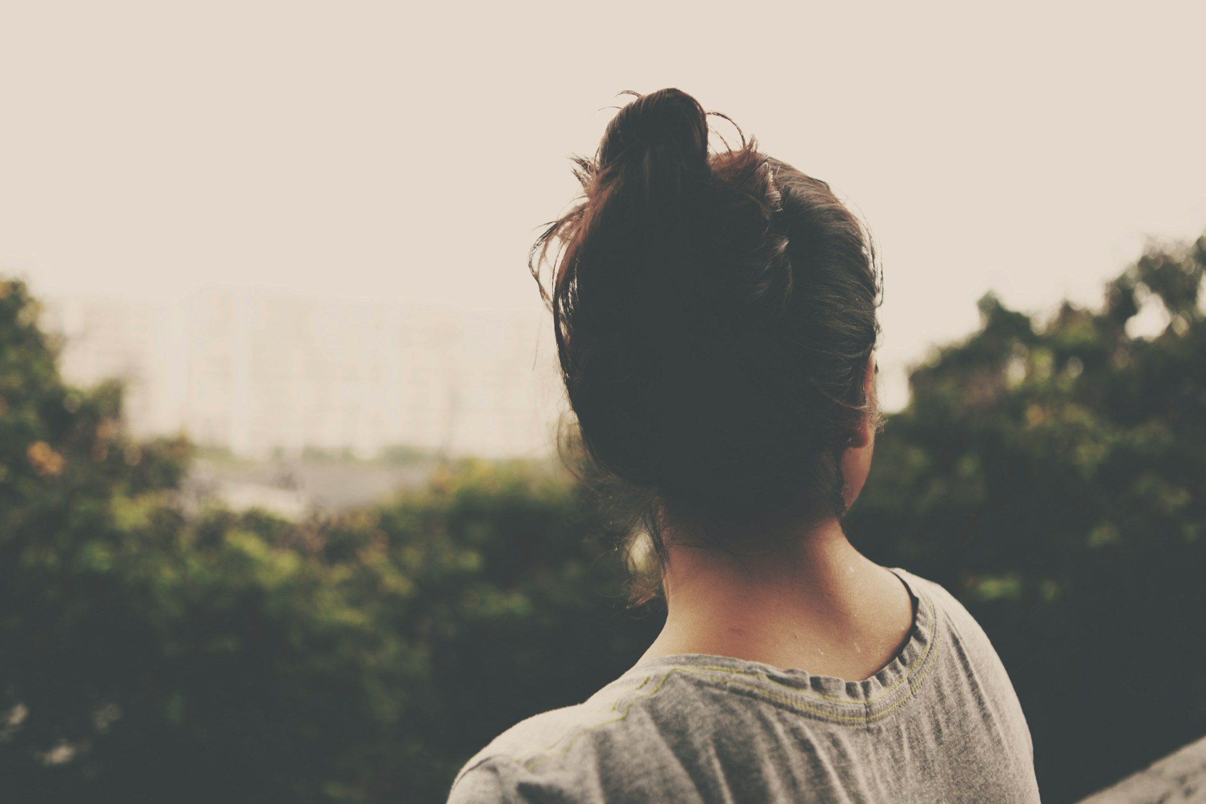 Una mujer sentada al aire libre mirando los árboles | Fuente: Unsplash