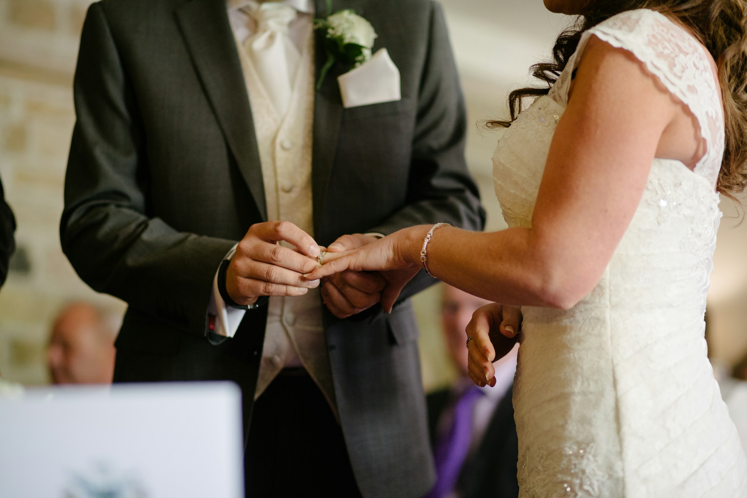 Primer plano de un novio colocando un anillo de boda en el dedo de su novia | Fuente: Unsplash