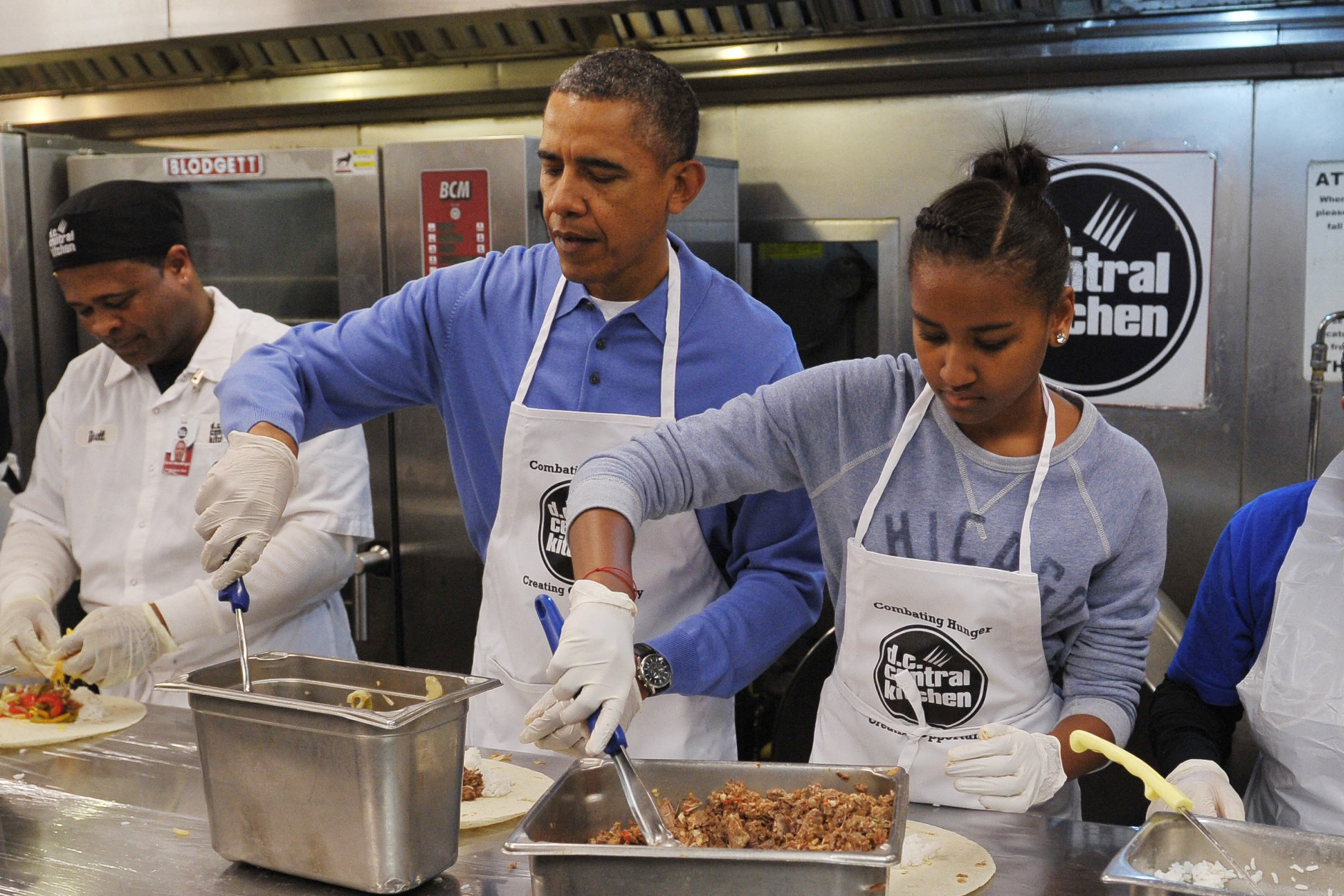 Barack y Sasha Obama participan en un proyecto de servicio comunitario, haciendo burritos para celebrar el Día de Martin Luther King Jr. en Washington, D.C., el 20 de enero de 2014 | Fuente: Getty Images