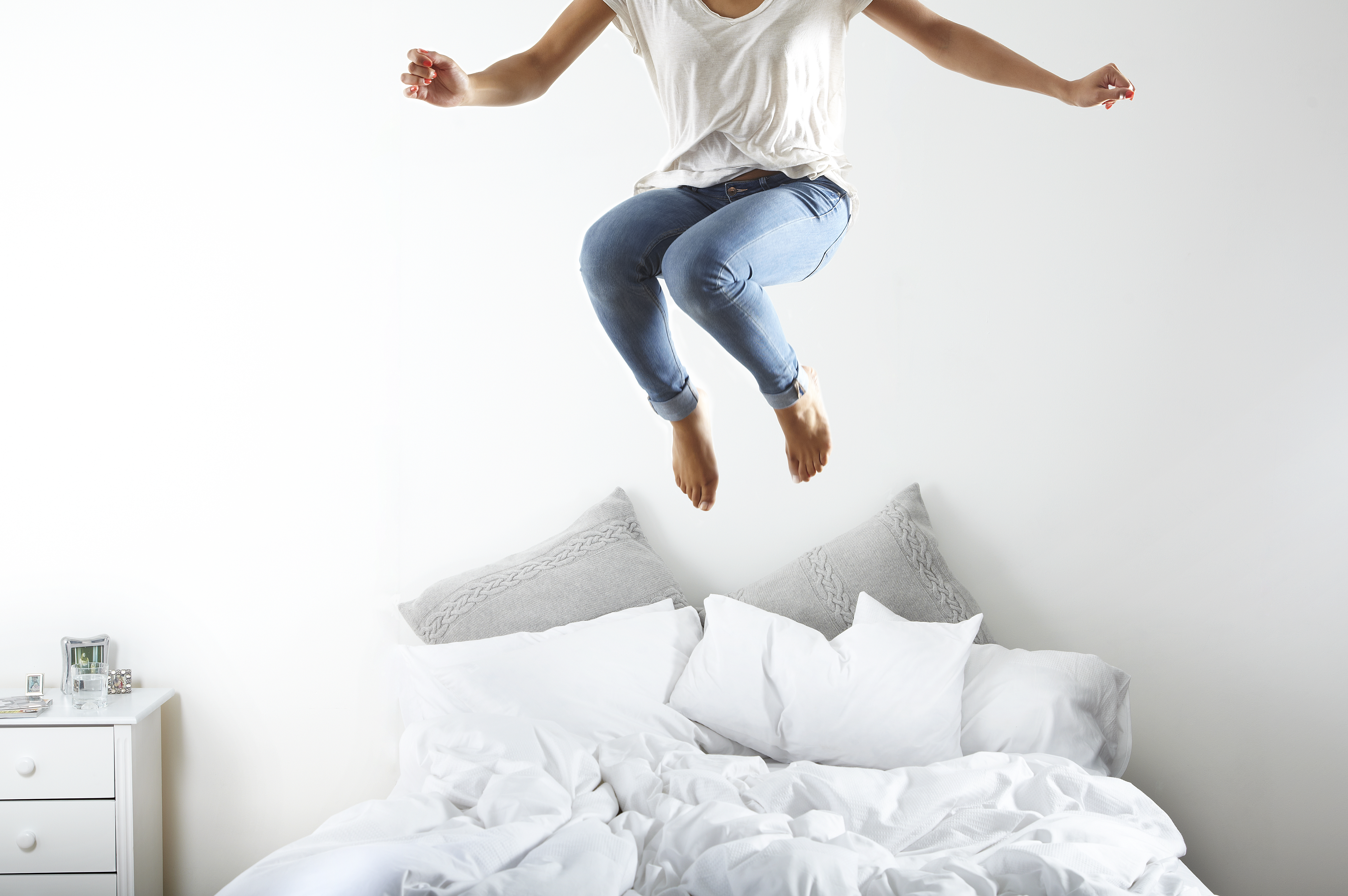 Retrato de mujer saltando en la cama | Foto: Getty Images