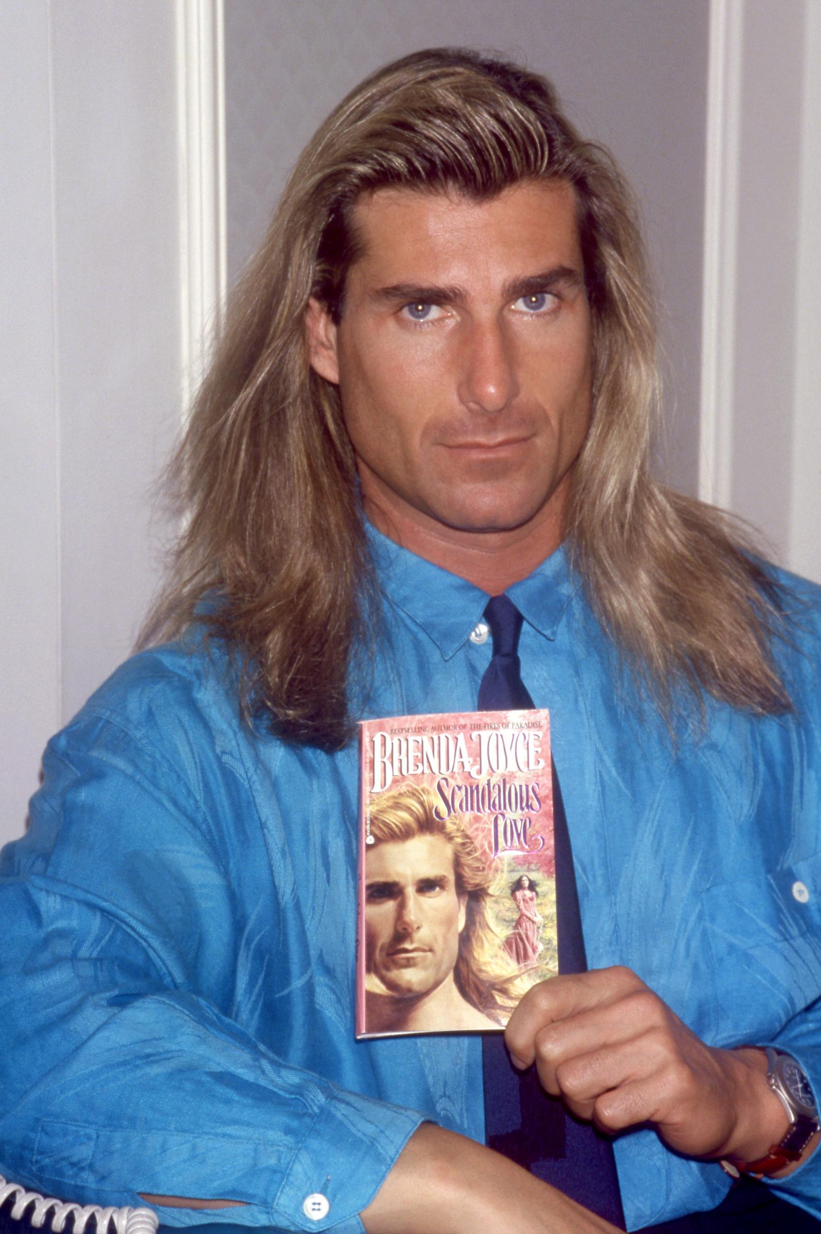 Pero pronto alcanzaría la fama en el lugar más inesperado. En esta foto, la icónica estrella de las portadas de novelas románticas posó para un retrato junto al libro de Brenda Joyce