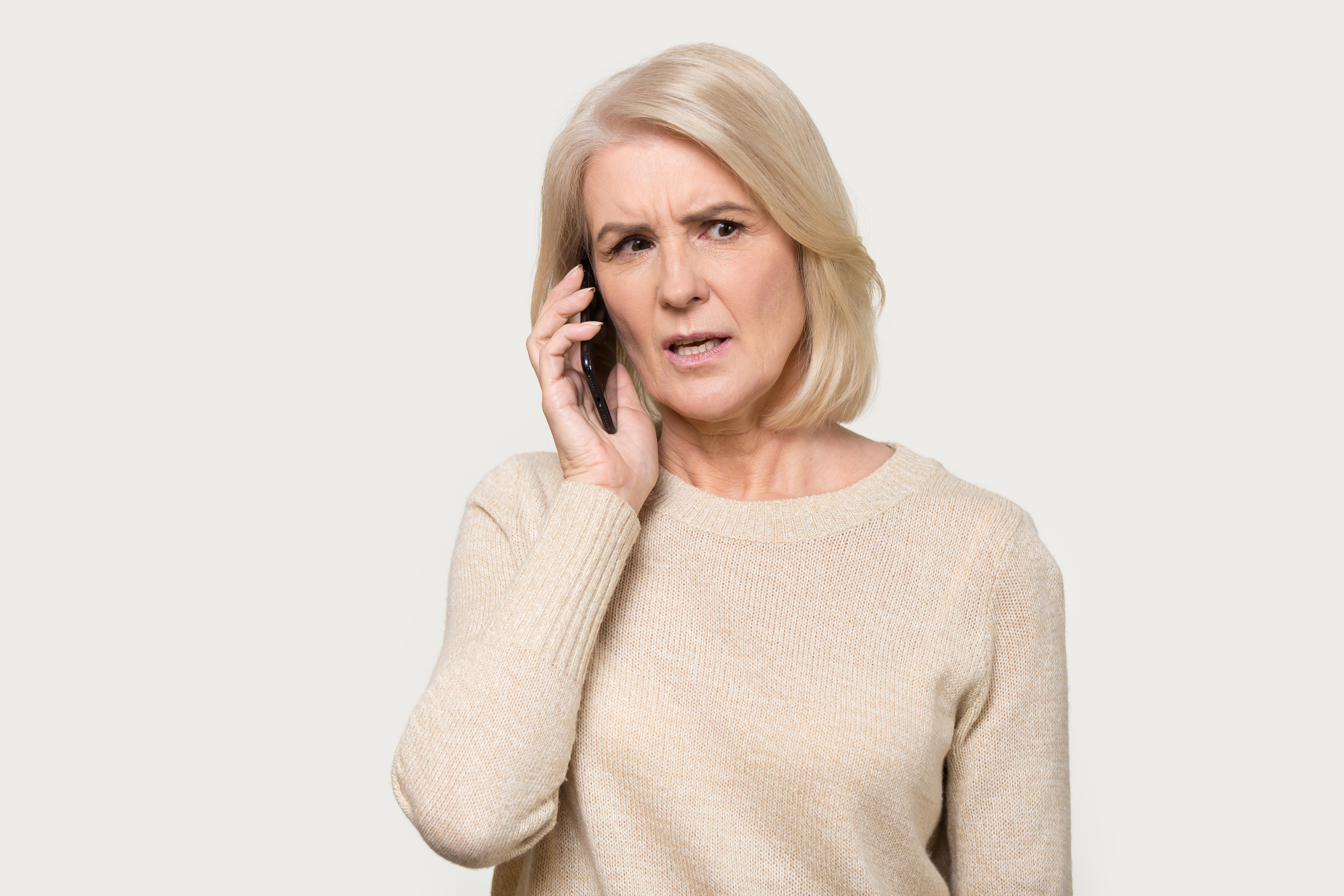 Una mujer con cara de preocupación mientras habla por teléfono | Fuente: Shutterstock