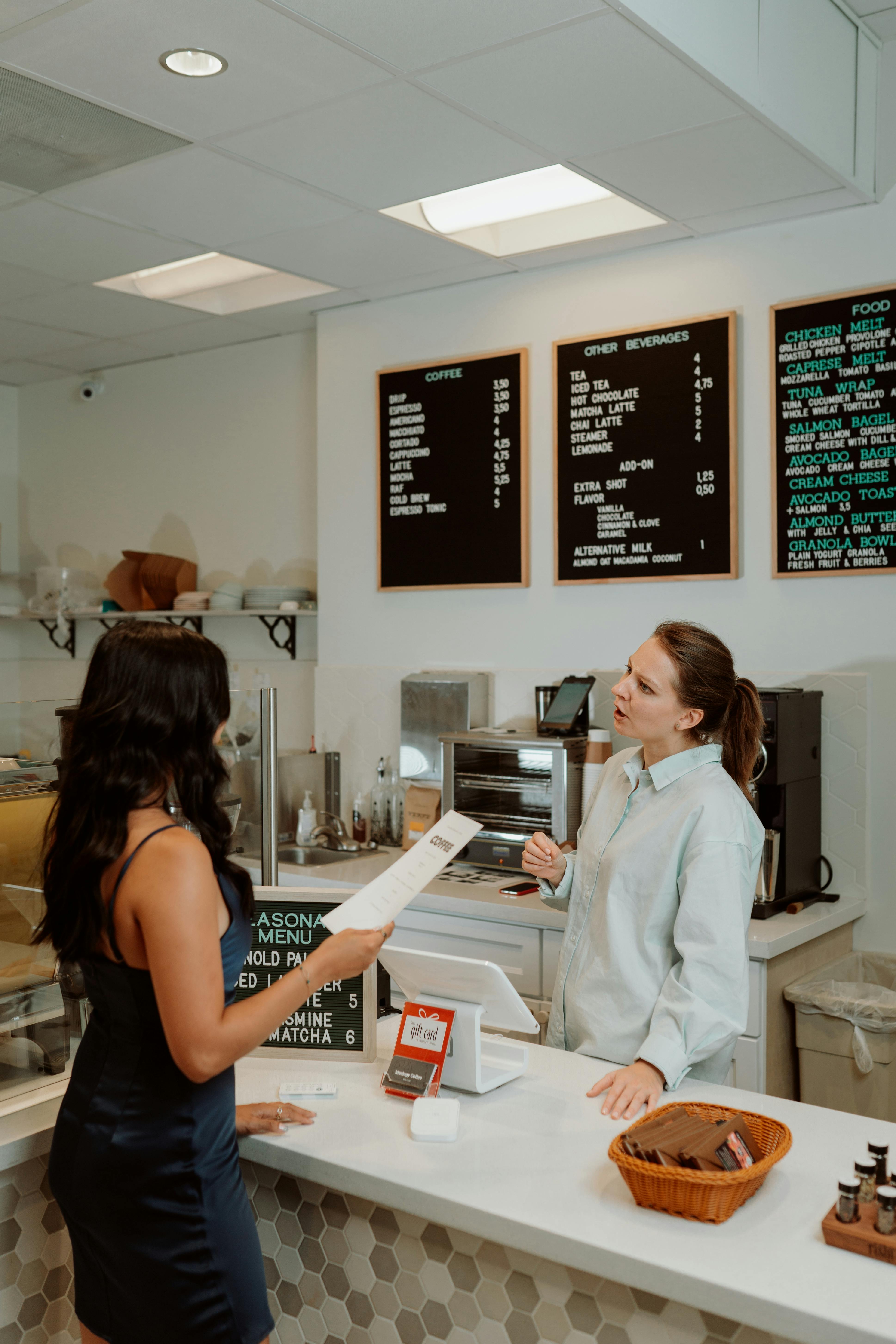 Una cajera conversando con un cliente | Fuente: Pexels