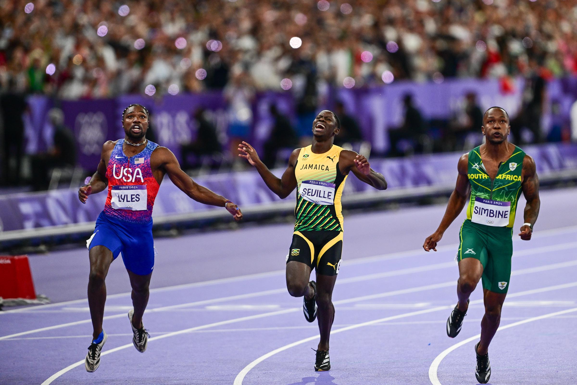 Noah Lyles, Oblique Seville y Akani Simbine compiten durante la final masculina de los 100 metros planos en los Juegos Olímpicos de París 2024 en Saint-Denis, Francia, el 4 de agosto de 2024 | Fuente: Getty Images