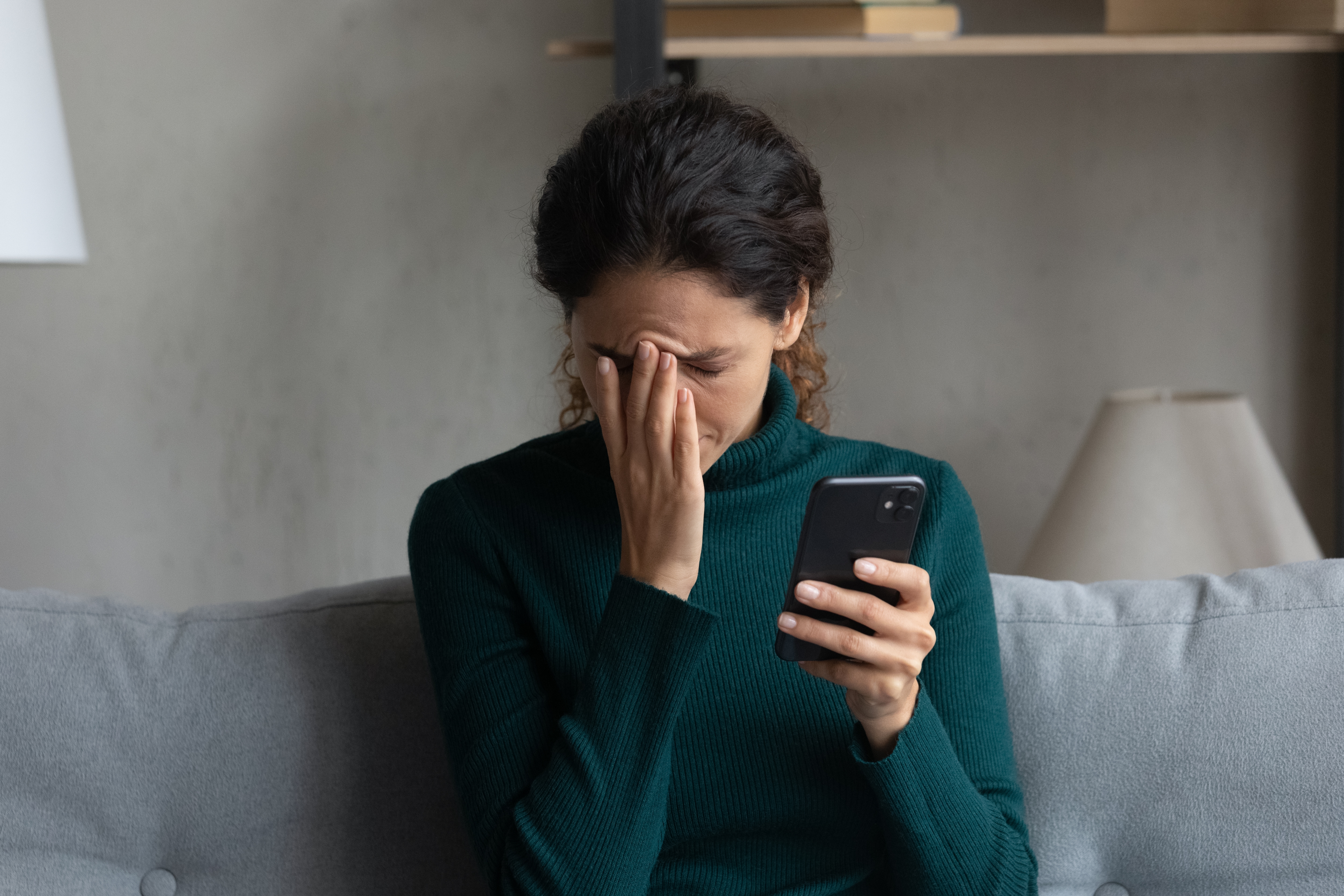 Mujer disgustada sostiene su teléfono | Foto: Shutterstock