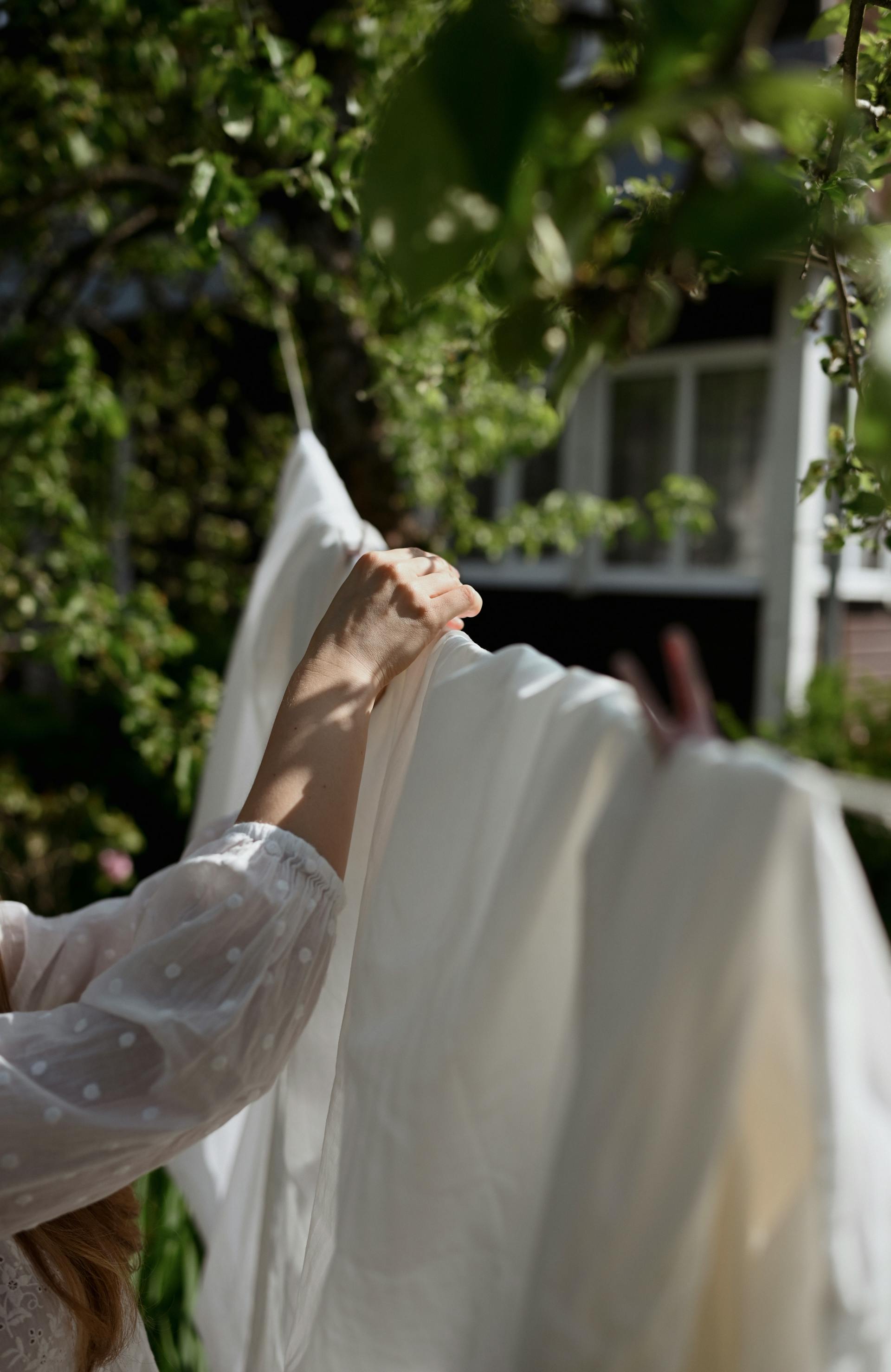 Una mujer tiende la ropa al aire libre | Fuente: Pexels