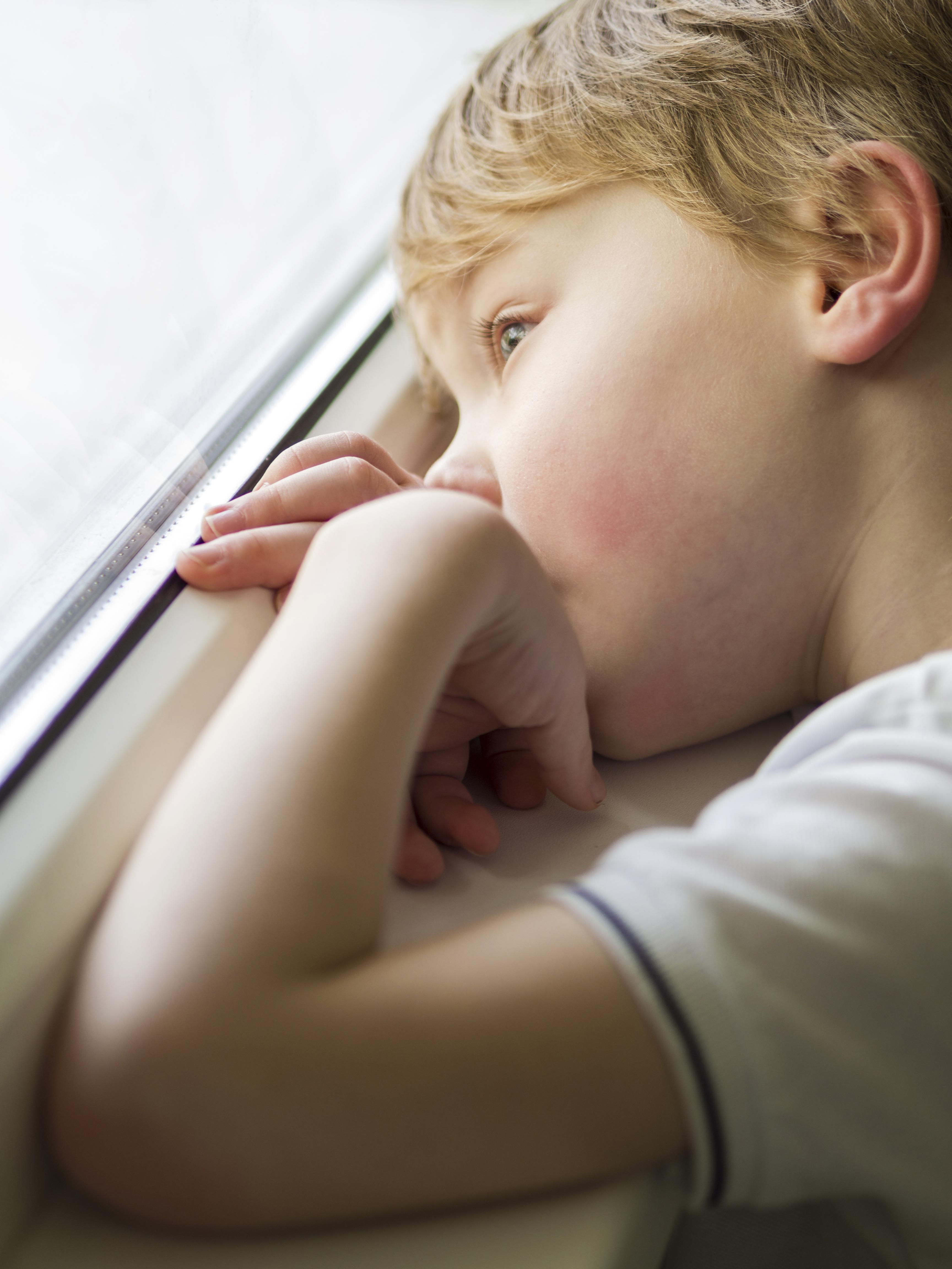 Un niño triste mirando por la ventana | Source: Freepik