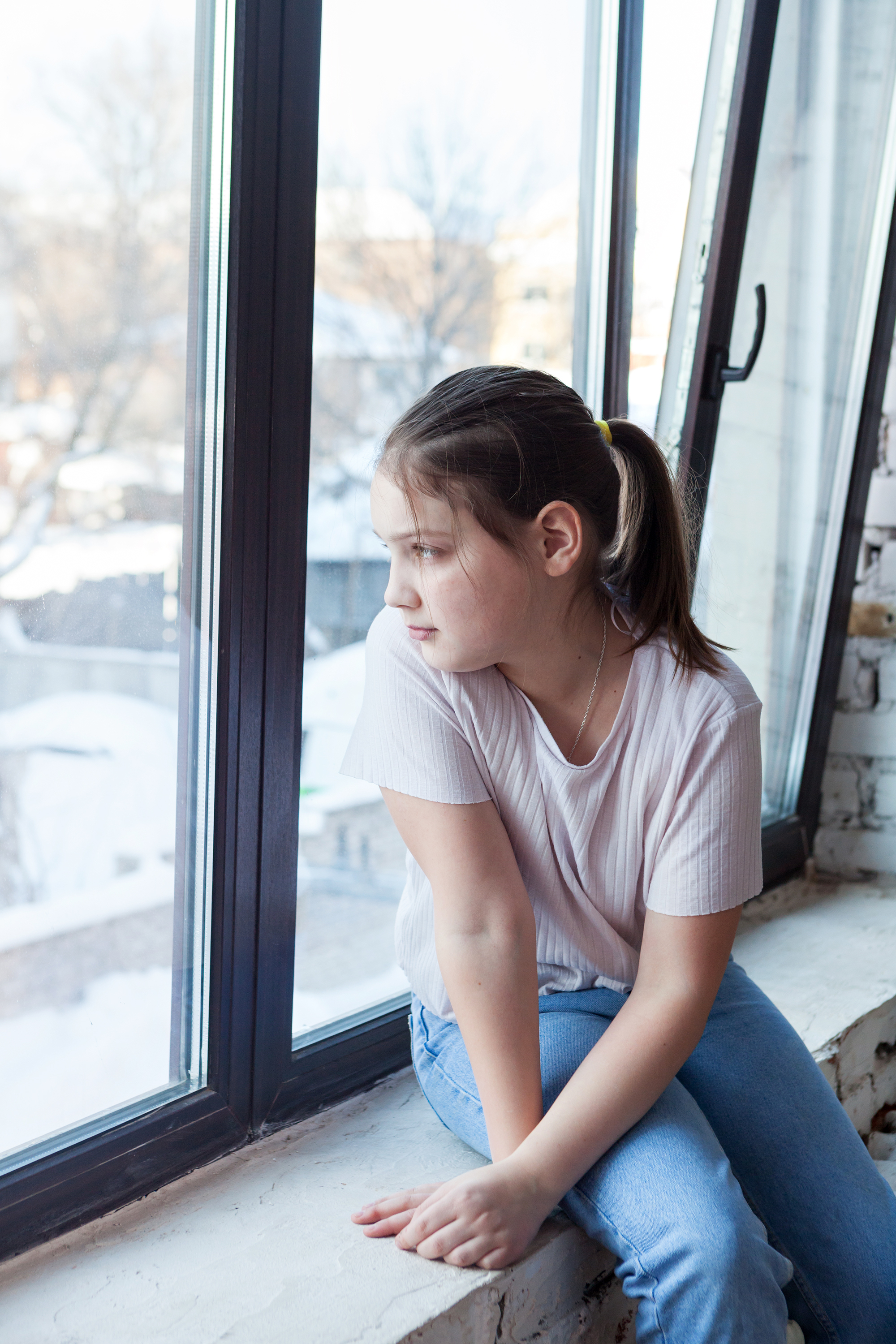 Chica joven mirando por la ventana | Foto: Shutterstock