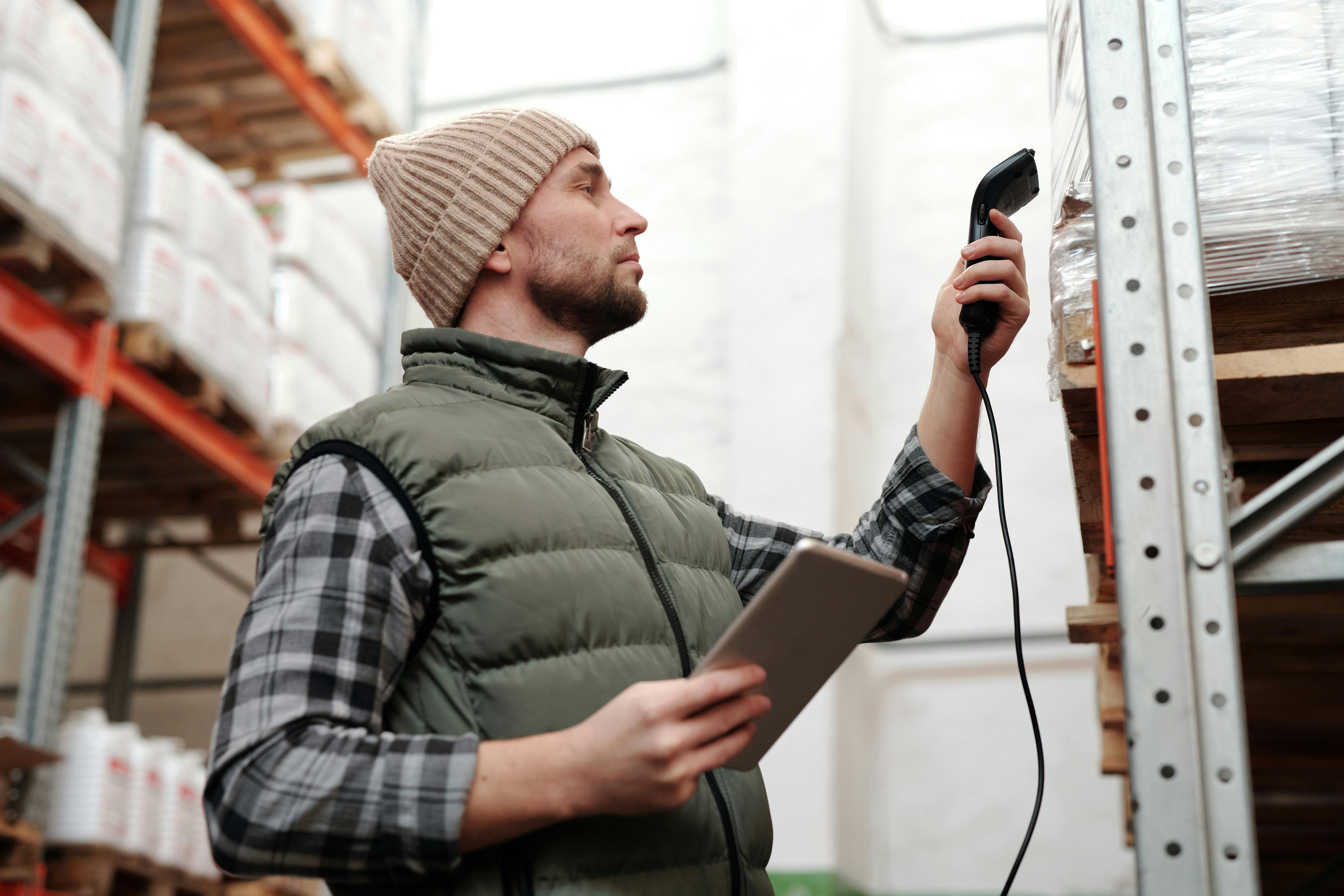 Un hombre escaneando productos en un almacén | Fuente: Pexels