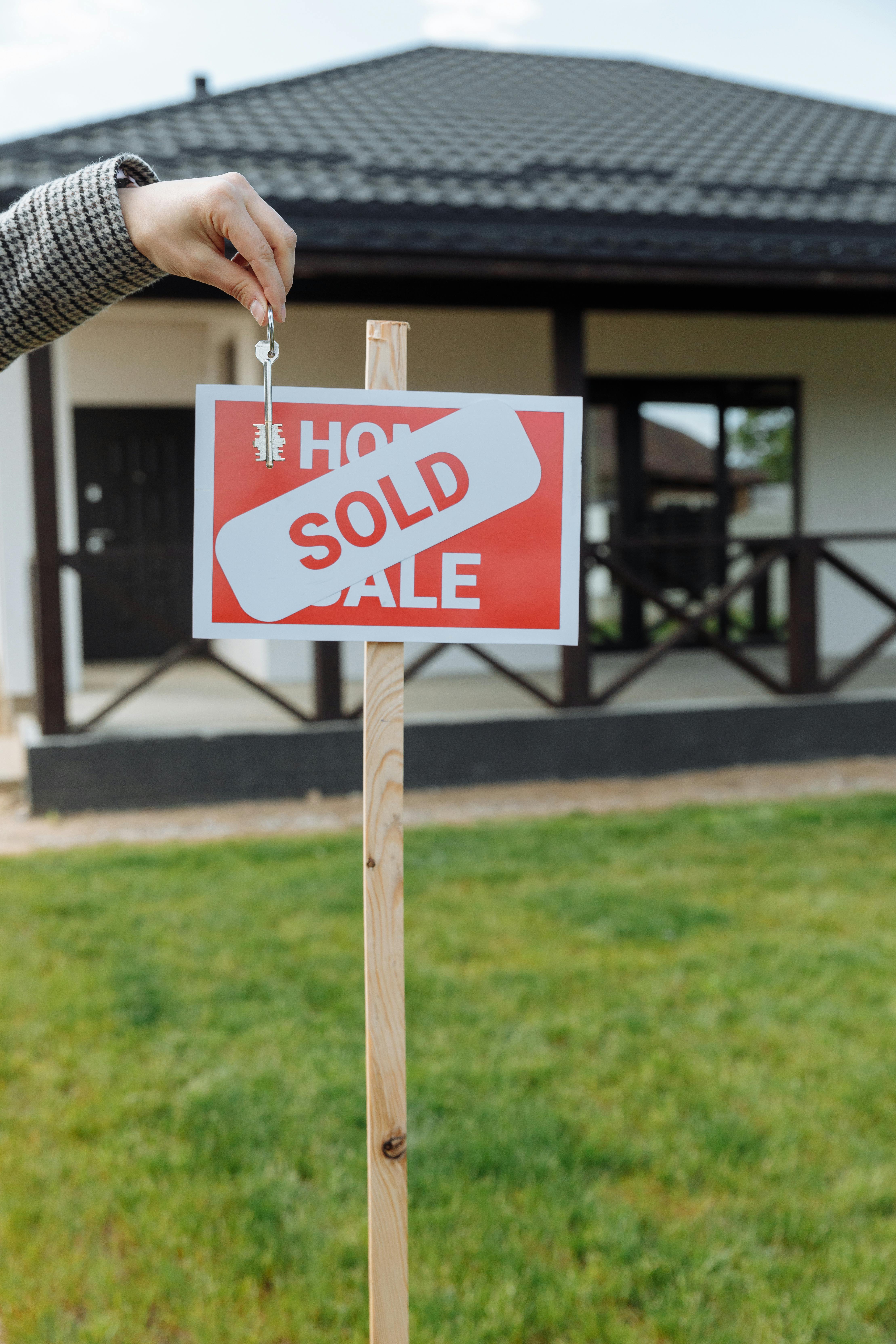 Un cartel de vendido en un jardín delantero | Fuente: Pexels
